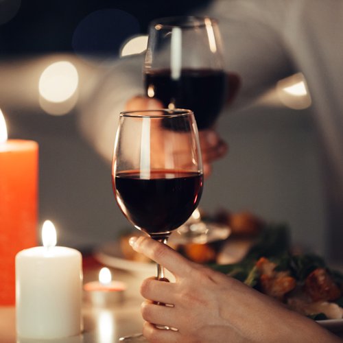 candle lit table with two glasses of wine in ambient setting