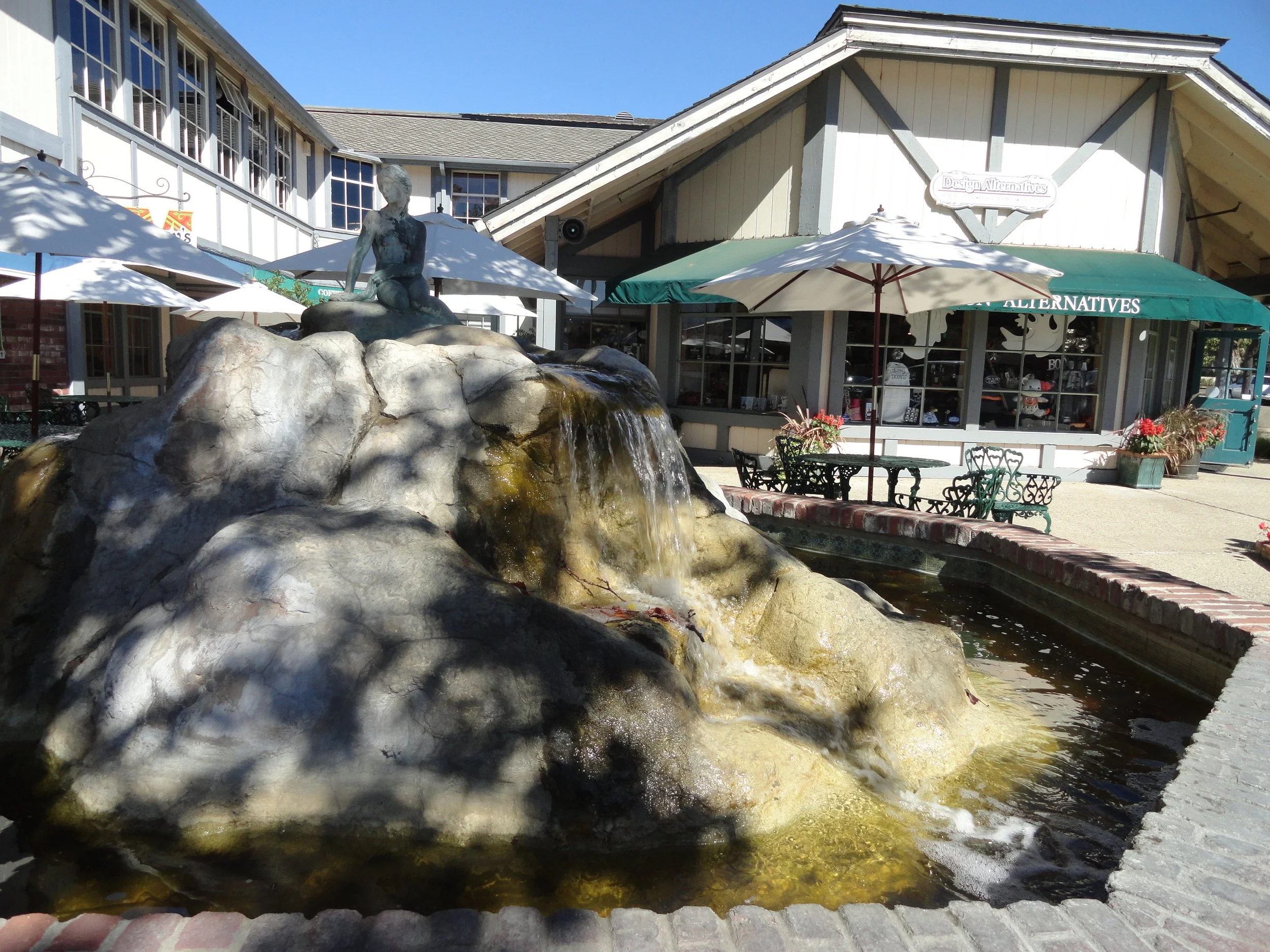 A fountain with a Little Mermaid statue on top in a old-world  square in Solvang, California