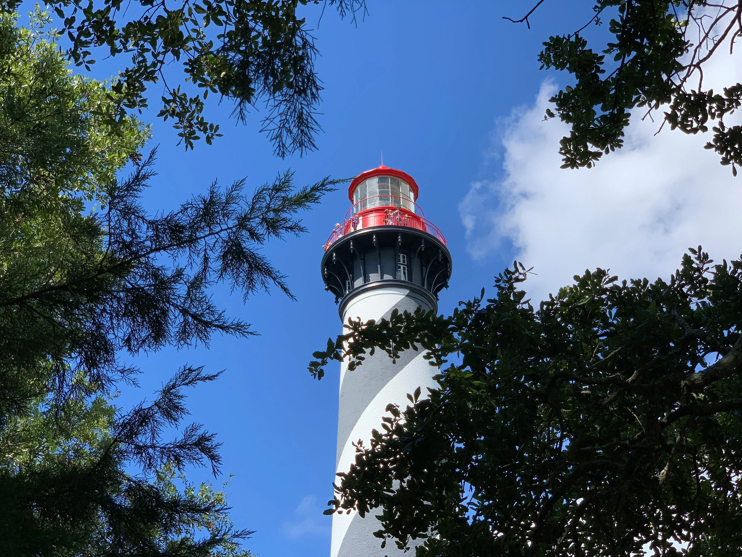 People look out from the red rails of a lighthouse in Florida.  Drives & Detours best things to do in St. Augustine