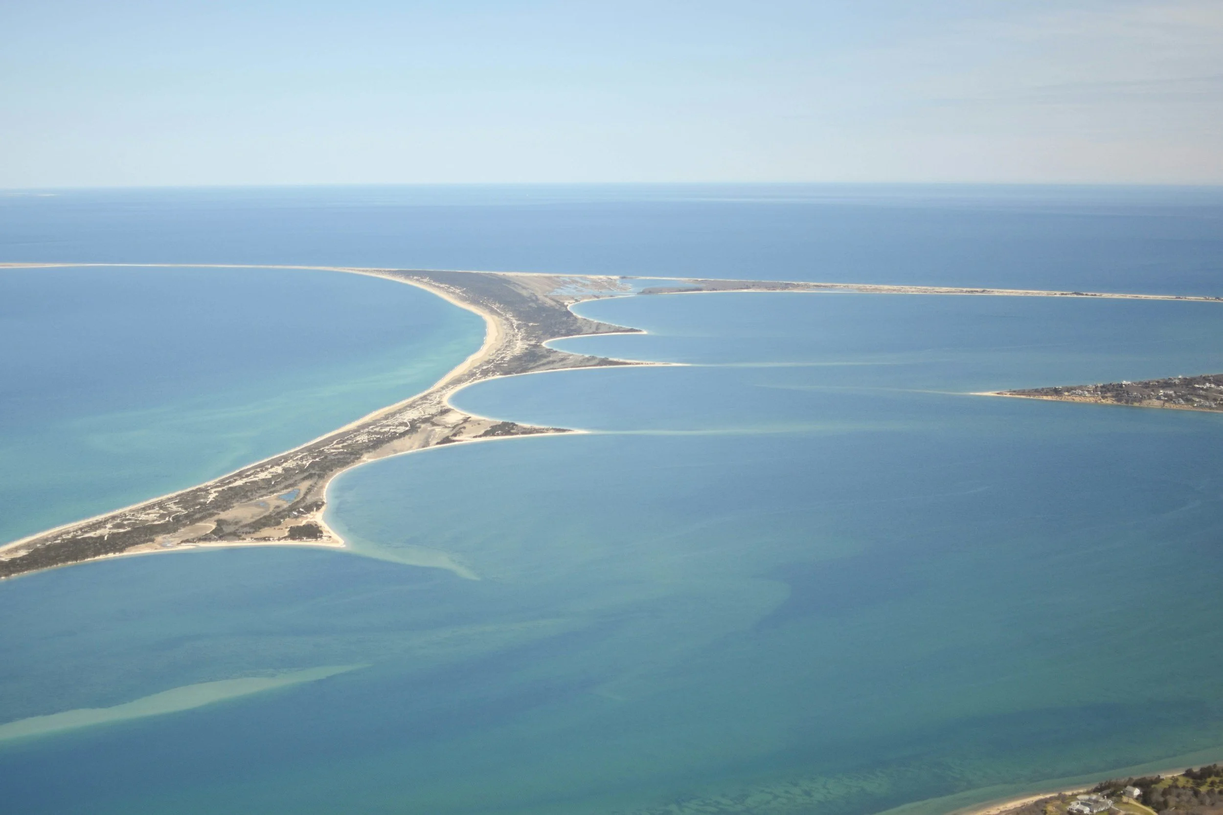 An aerial shot of a spit of sand running out into the sea on Nantucket. You can see the curves where the tides have shaped the the sand