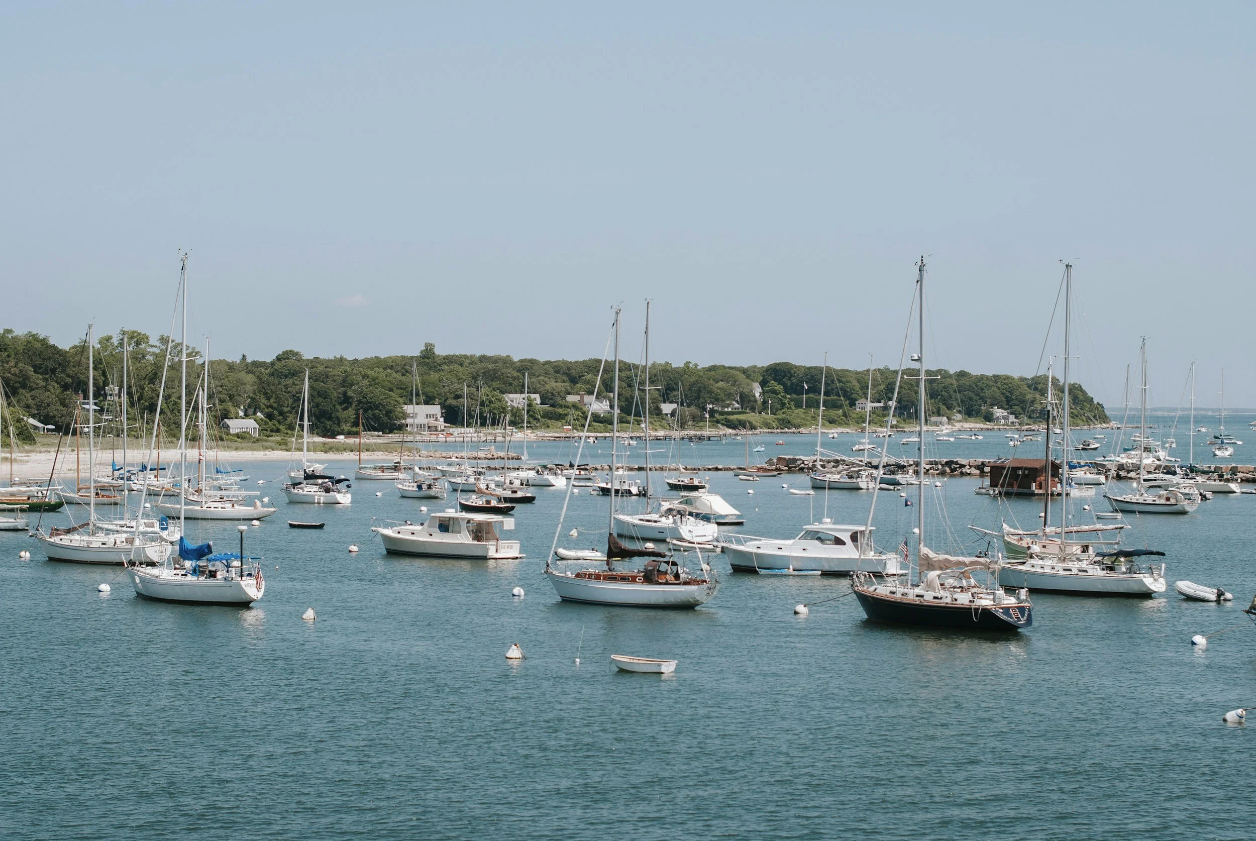 Small boats and yachts float in the calm ocean in a harbor at Oak Bluffs, Martha’s Vineyard.