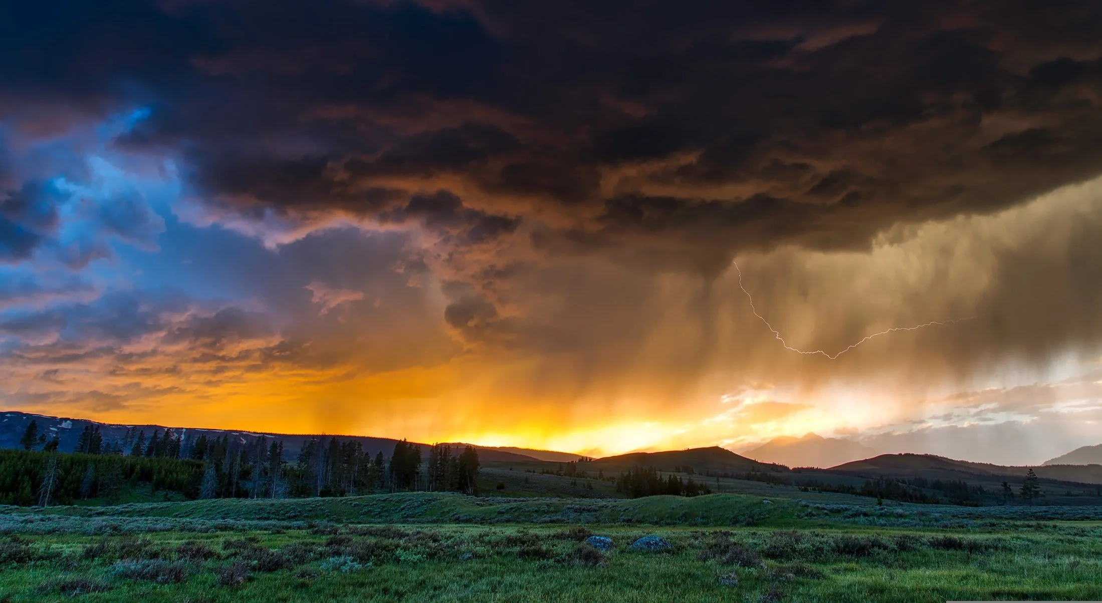 Lightning arcs through the air as the sun sets behind a storm