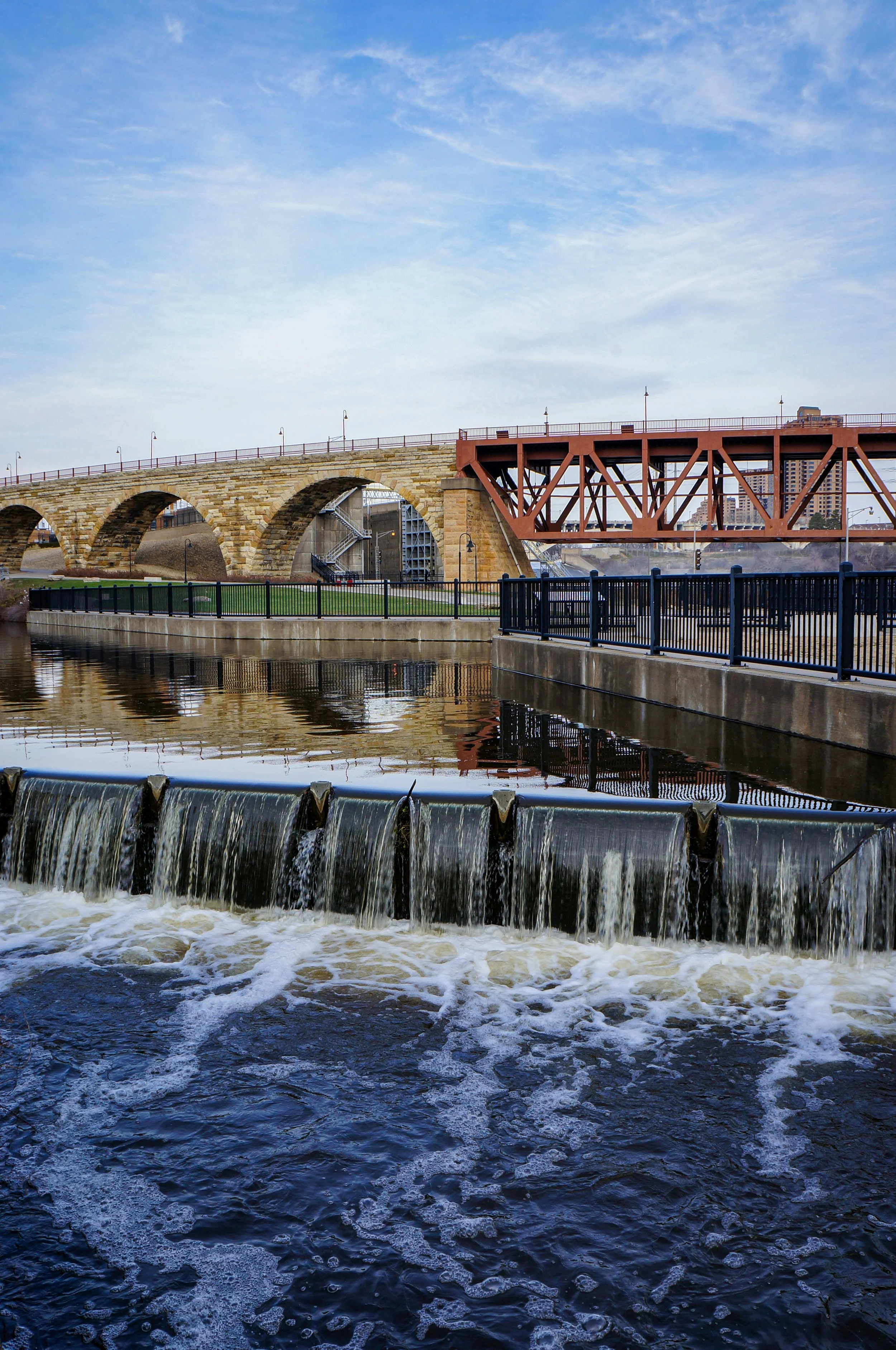 Water tumbles over a weit beside the Stone Arch Bridge in Minneapolis