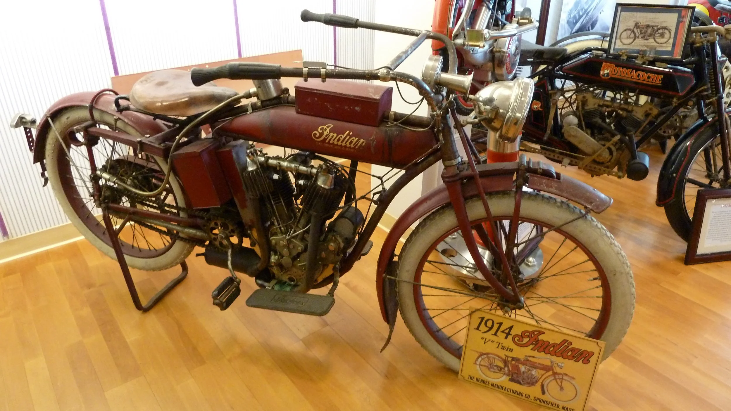 A brown 1914 Indian V Twin motorbike with white tires in Solvang Vintage Motorcycle Museum.