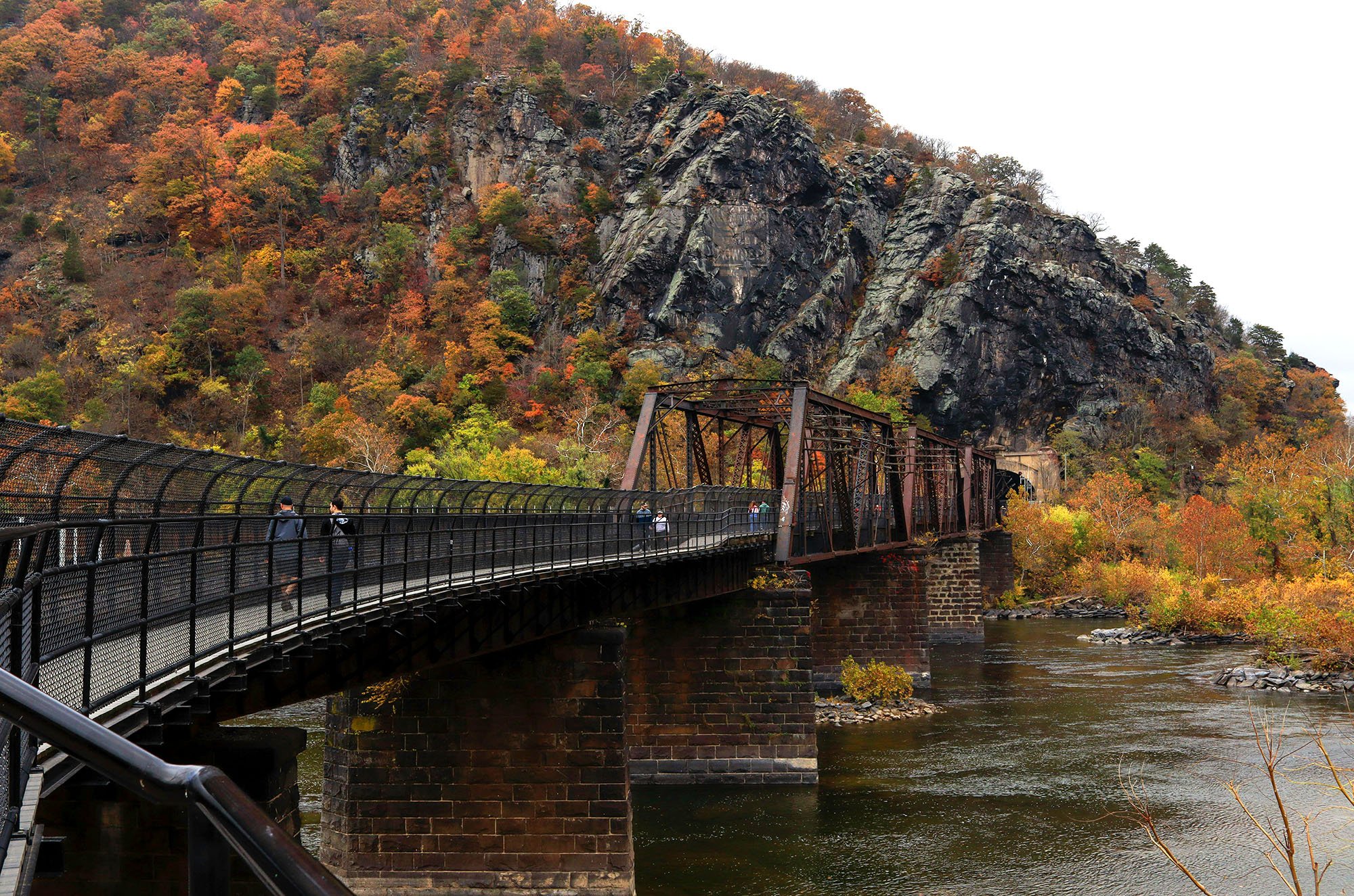 An old iron rail bridge crosses a river at the confluence of the Potomac and Shenandoah. Drives & Detours Harpers Ferry history
