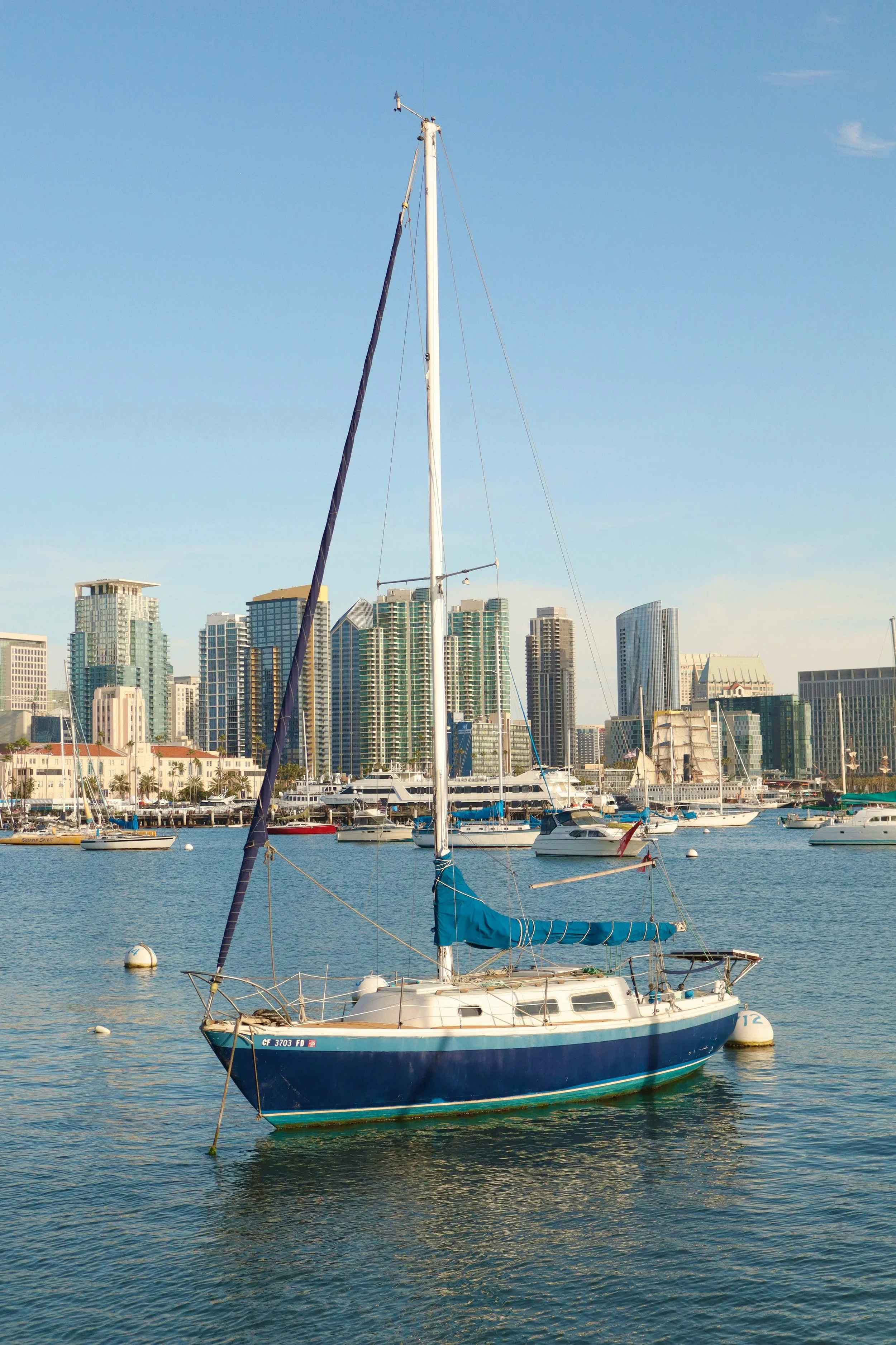 A yacht floats in the harbor of San Diego Bay. Drives & Detours USS Midway Museum and Embarcadero Self-Guided Tour