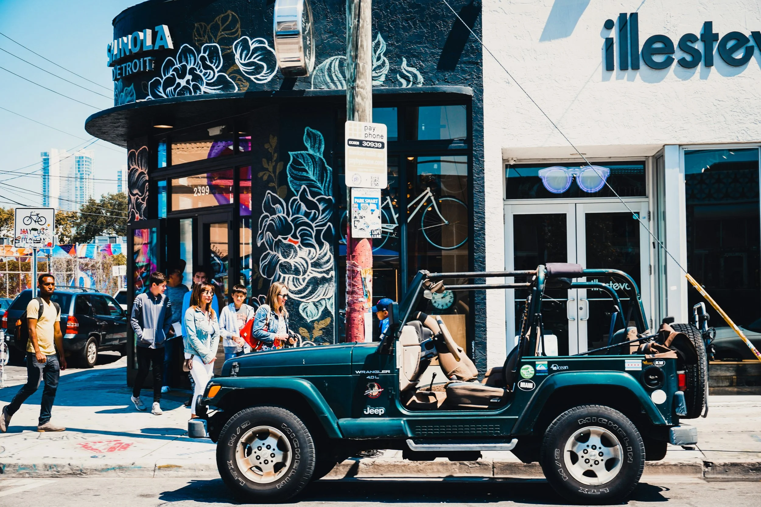A Jeep Wrangler sits on a street in front of graffiti. best places to eat in Wynwood