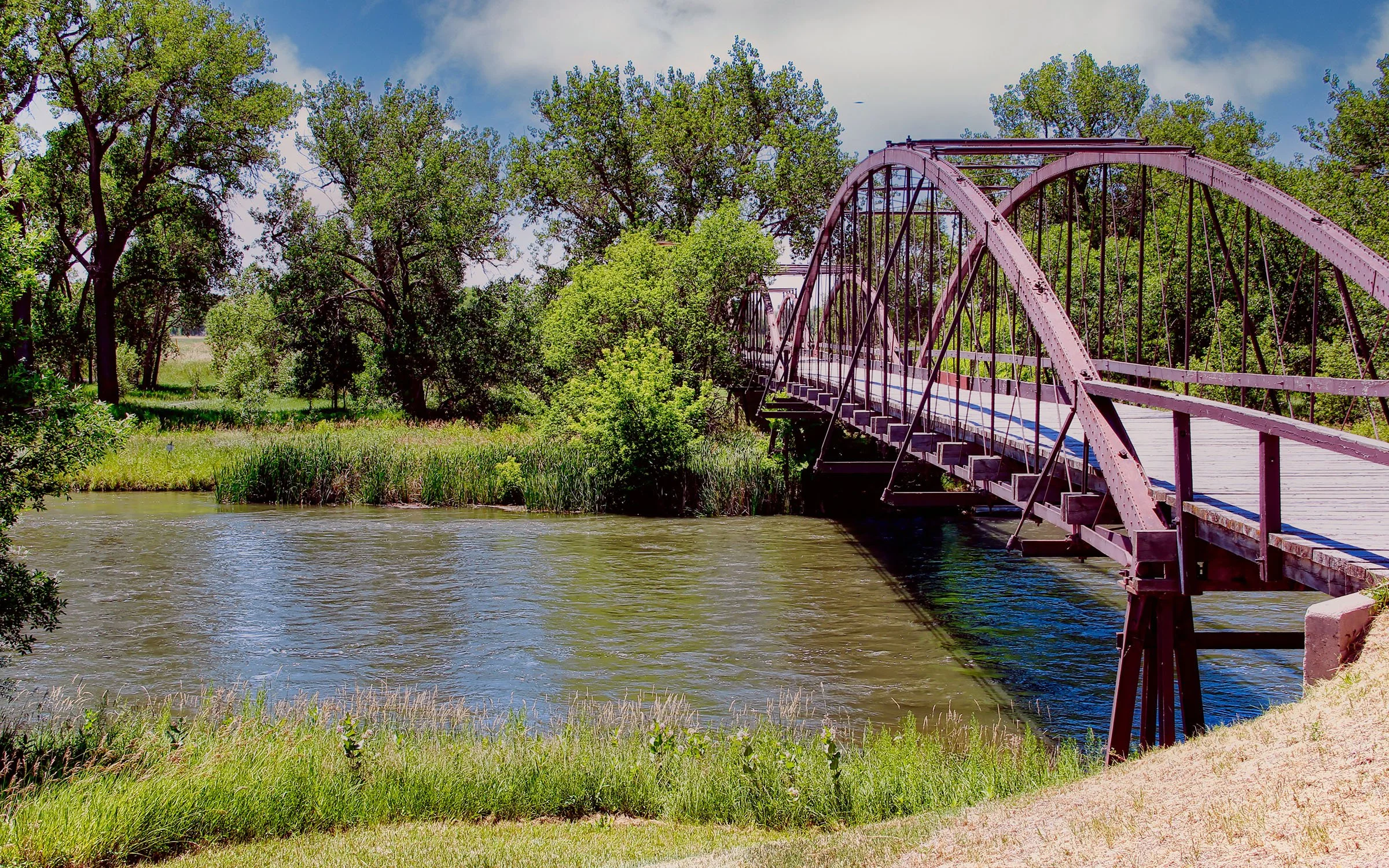 An iron bridge crosses a river in Wyoming. Drives & Detours Fort Laramie tour