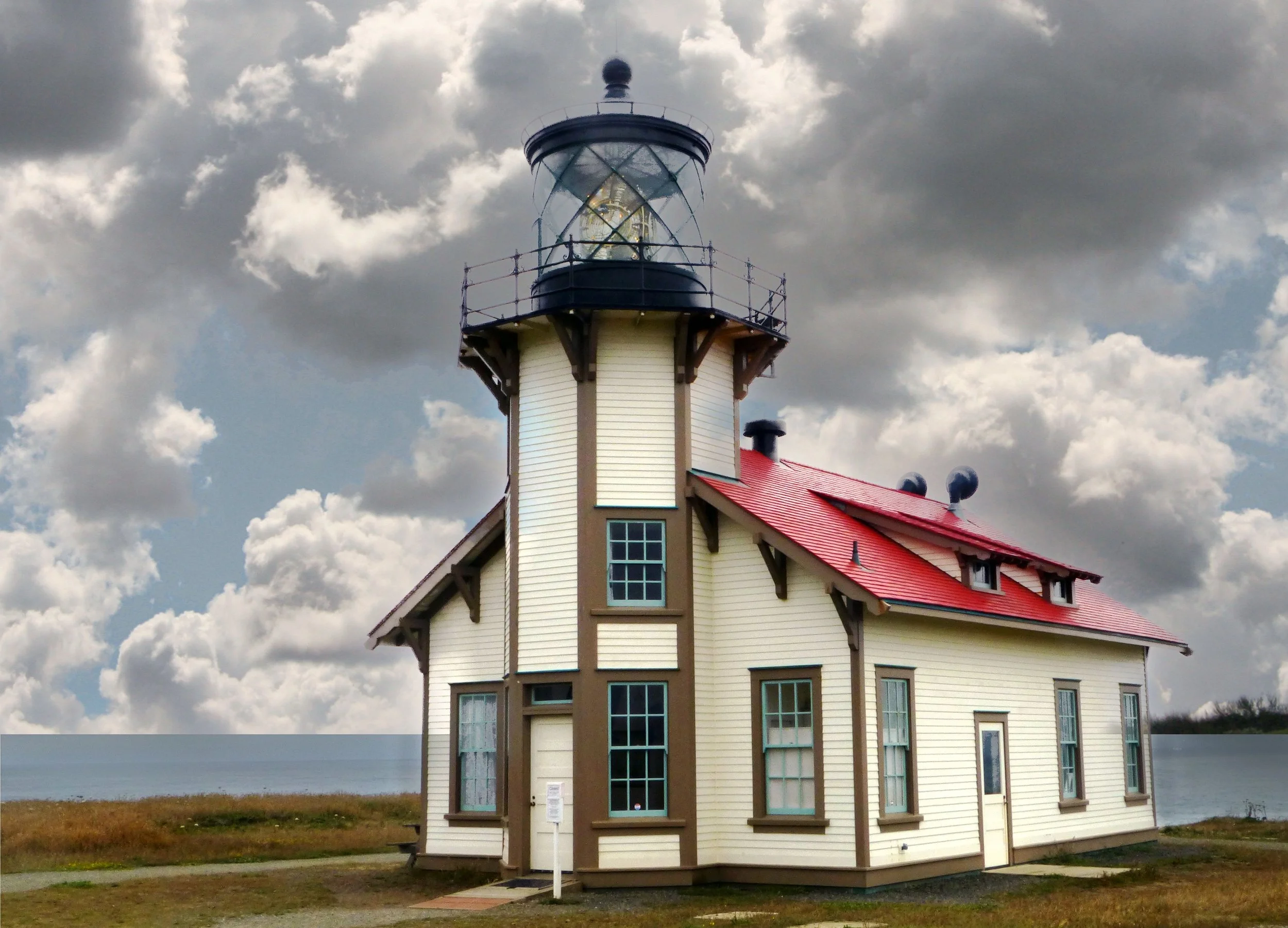 A small red and white wooden lighthouse with the Pacific Ocean and California Coast behind it at Point Cabrillo. Drives & Detours Mendocino top attractions