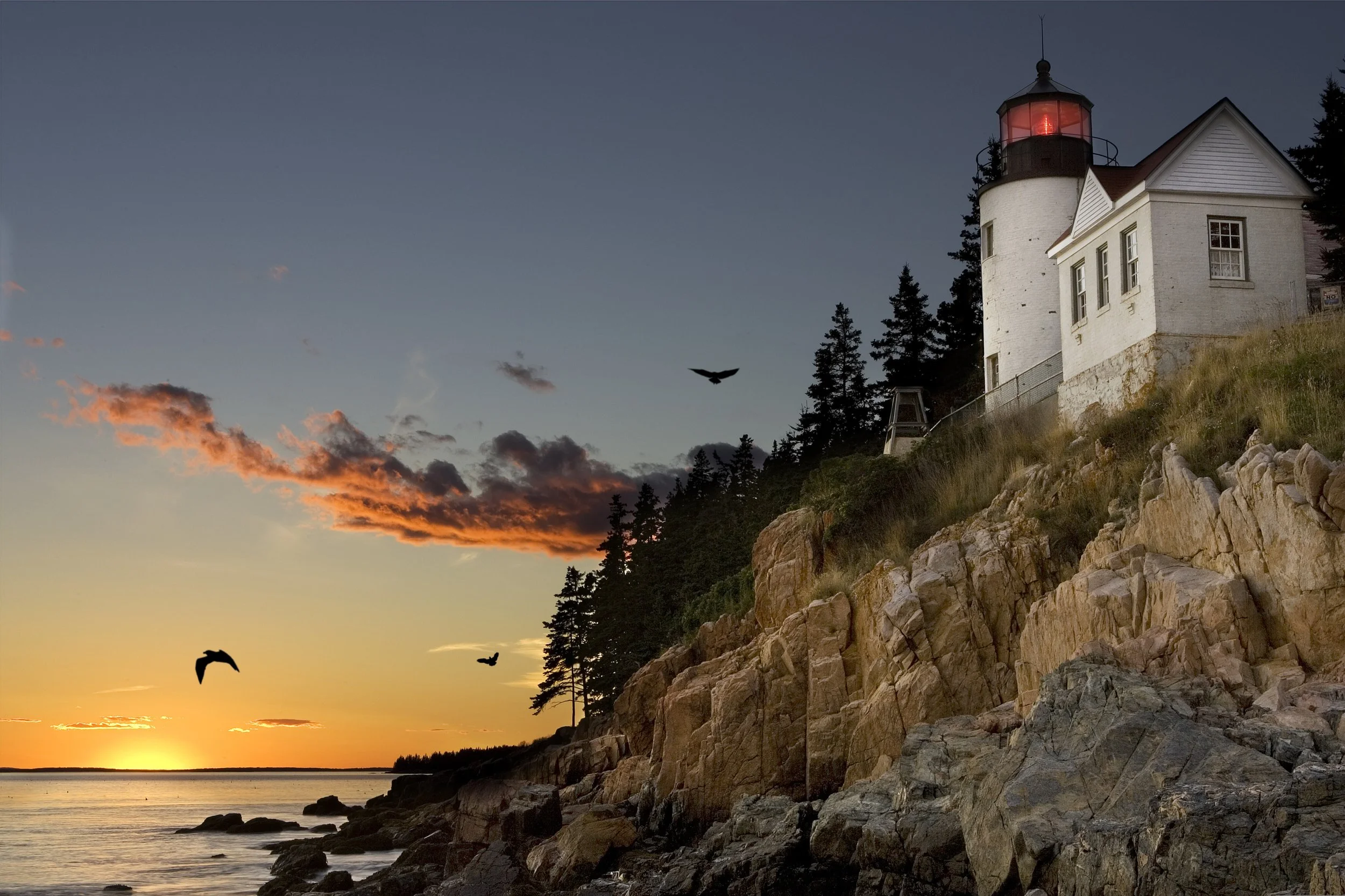 A little lighthouse sits on top of a cliff near Portland at sunset