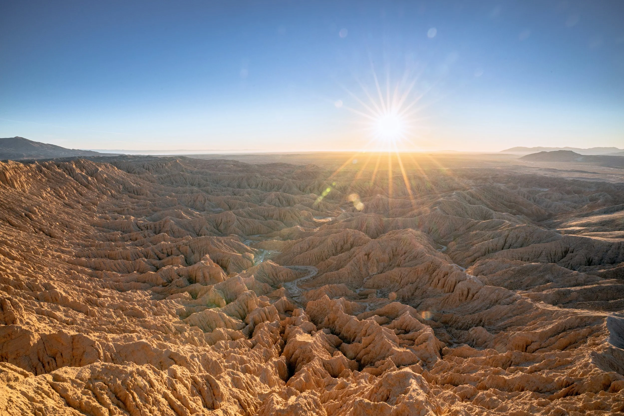 The sun disappears in the desert of Anza-Borrego Desert State Park. The rock formations are beautiful ridges