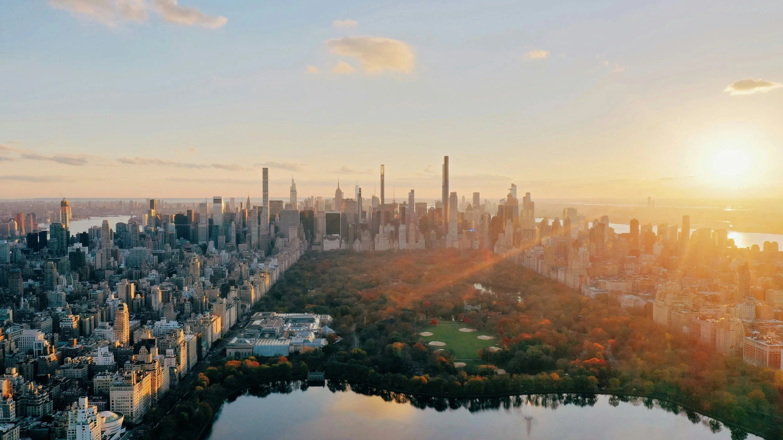 An aerial picture of Central Park, New York, at sunset that shows the scale of the park and the skyscrapers that surround it