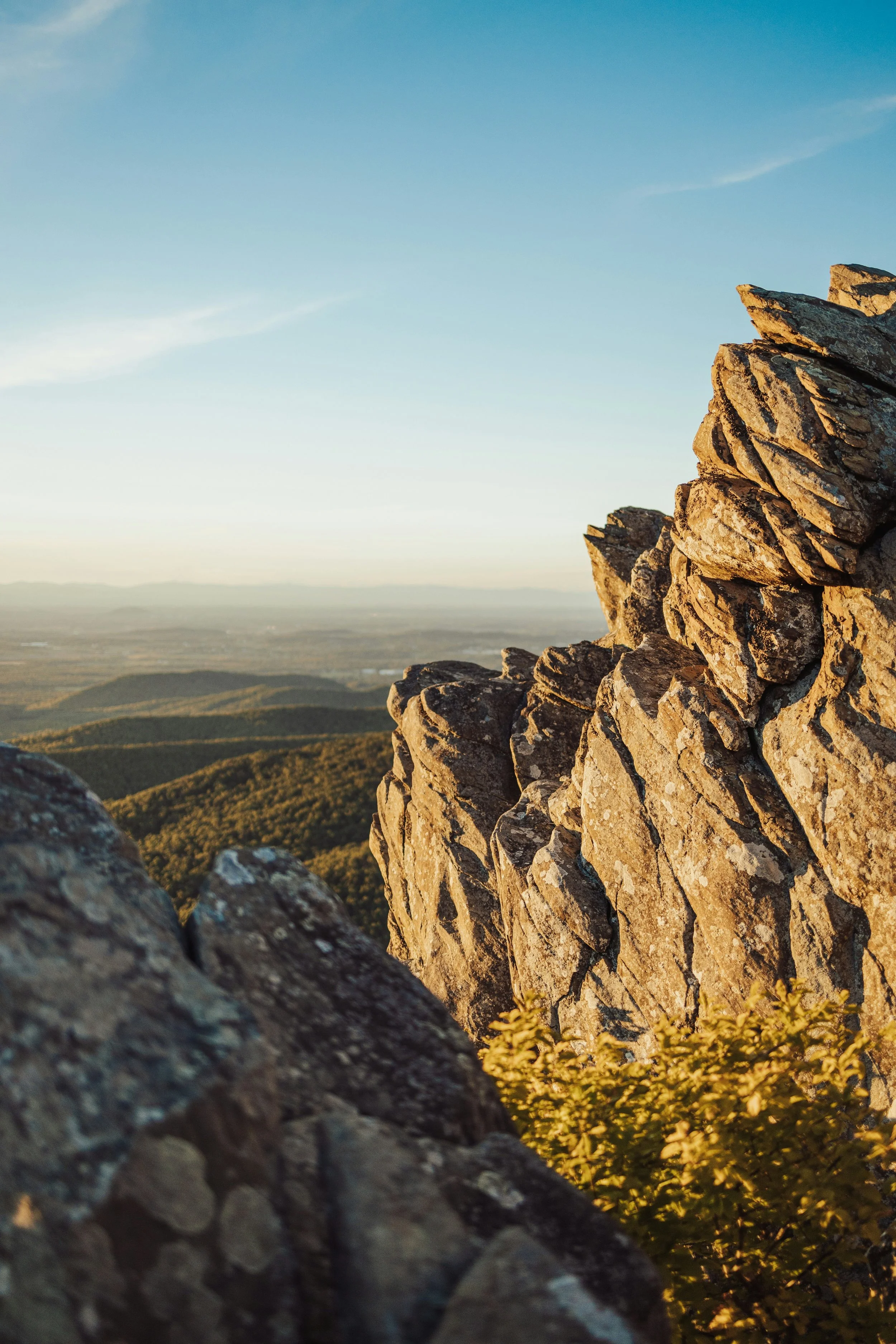 Large rock formations fill the foreground while the forests of Skyline Drive and Shenandoagh National Park stretch out in the distance across rolling hills