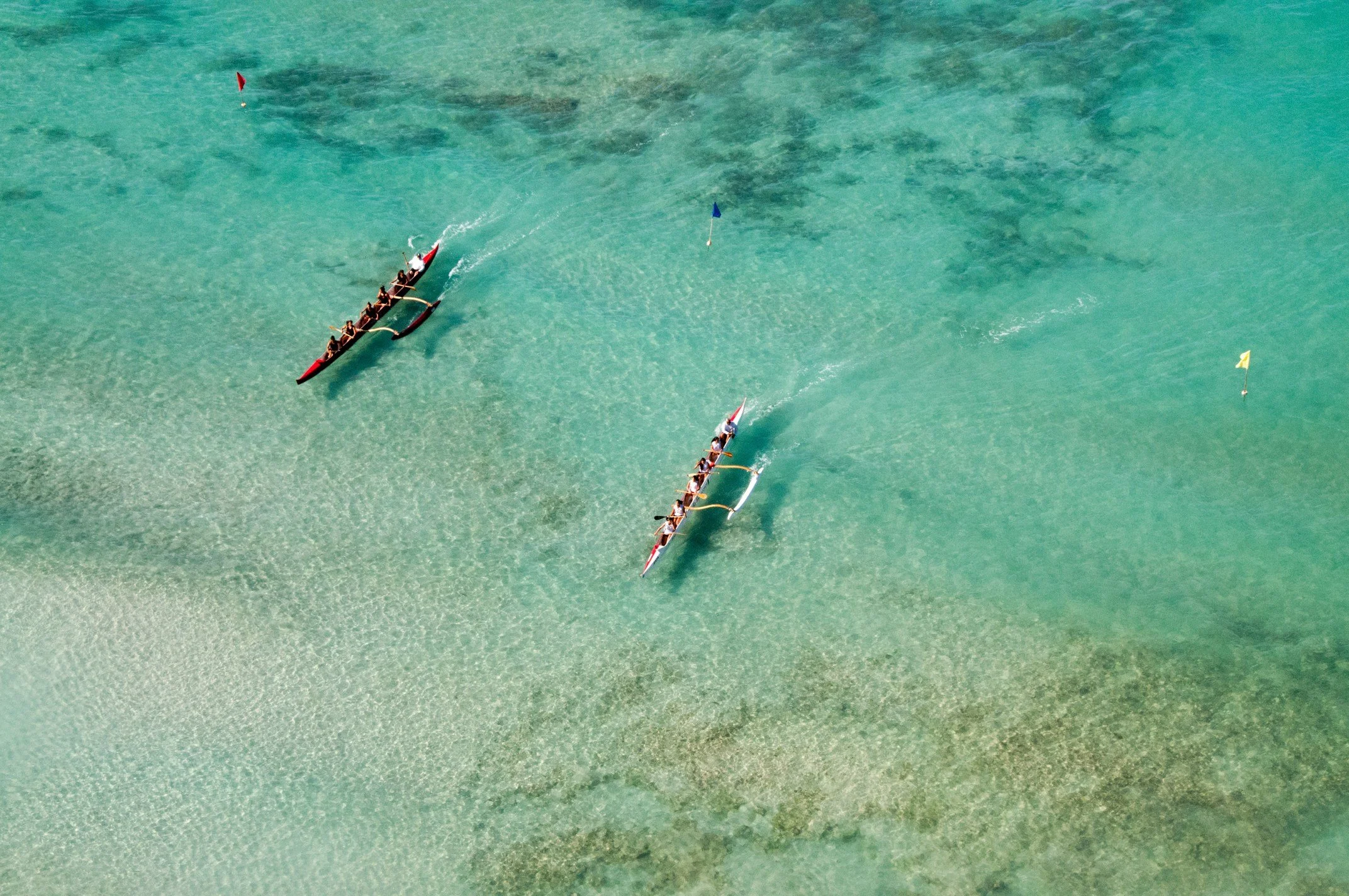 People paddle canoes through blue water in Honolulu. Drives & Detours Waikīkī walking tour