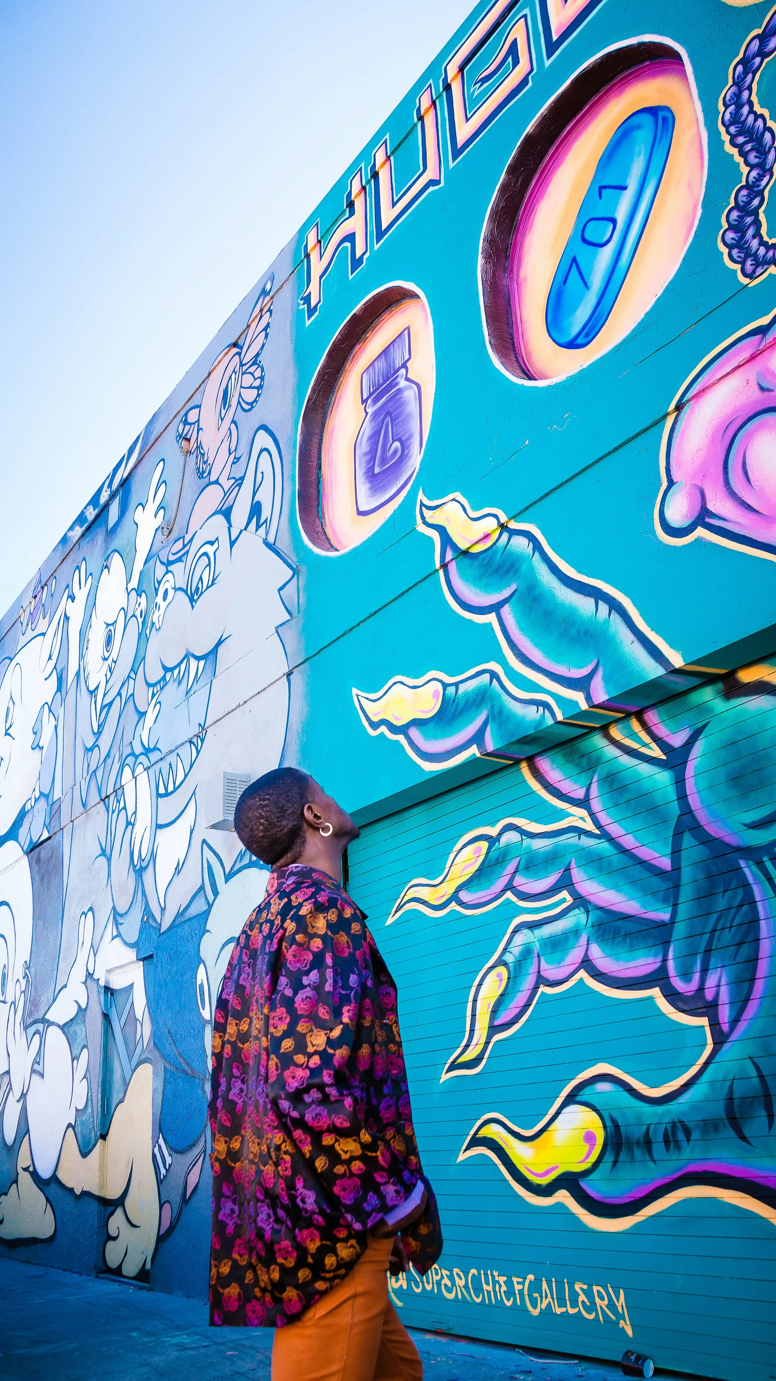A man looks up at street art painted on the Wynwood Walls in Miami. It's hard to tell exactly what he's looking at from the angle