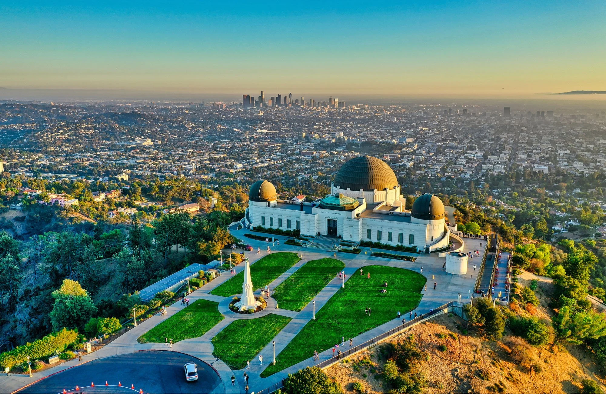 The domes of the Griffith Observatory in Los Angeles, with Downtown LA in the distance behind it. Drives & Detours Self-drive holiday planning