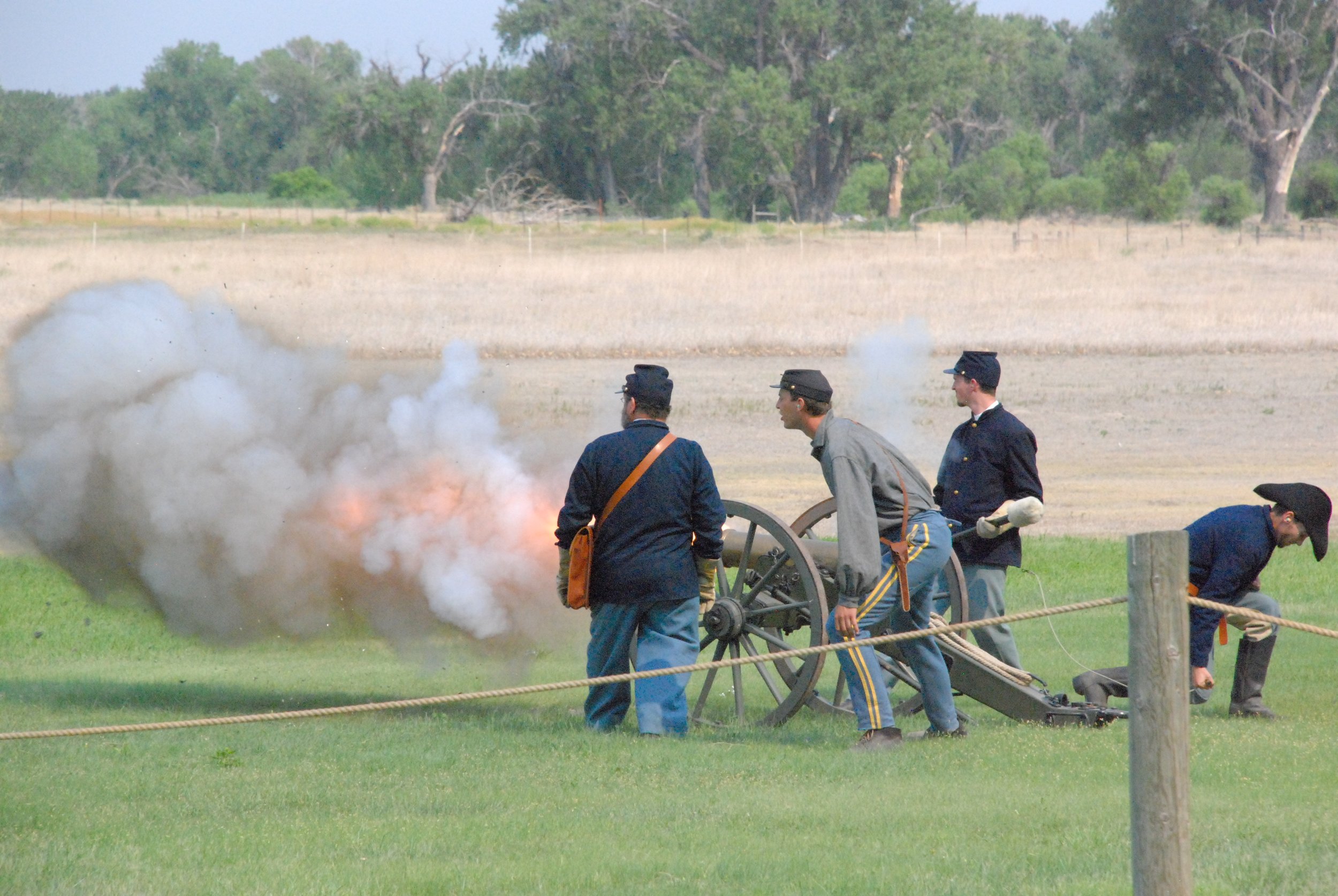 Men fire a cannon during a Civil War reenactment. Drives & Detours Fort Laramie tour