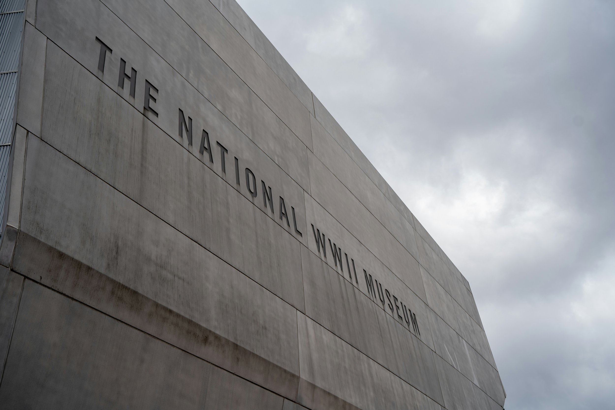 The words the National WWII Museum are embossed on the side of a grey building. Drives & Detours New Orleans walking tour