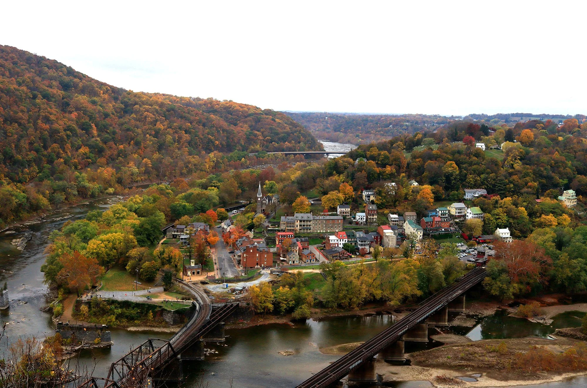 An aerial shot of Harpers Ferry showing the town surrounded by fall foliage