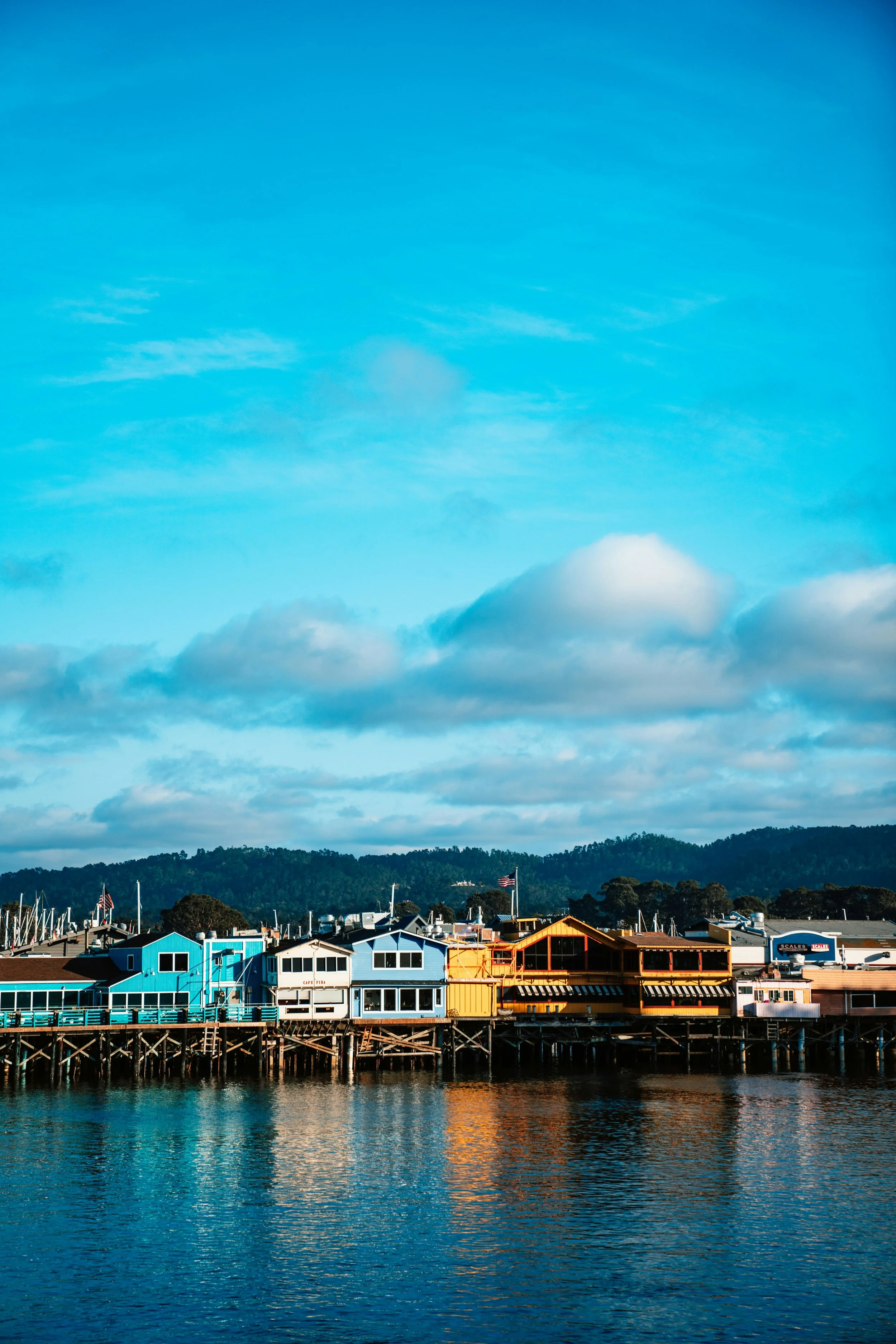 Multicolored wooden buildings line the seafront of Monterey, California. Drives & Detours Monterey Tour
