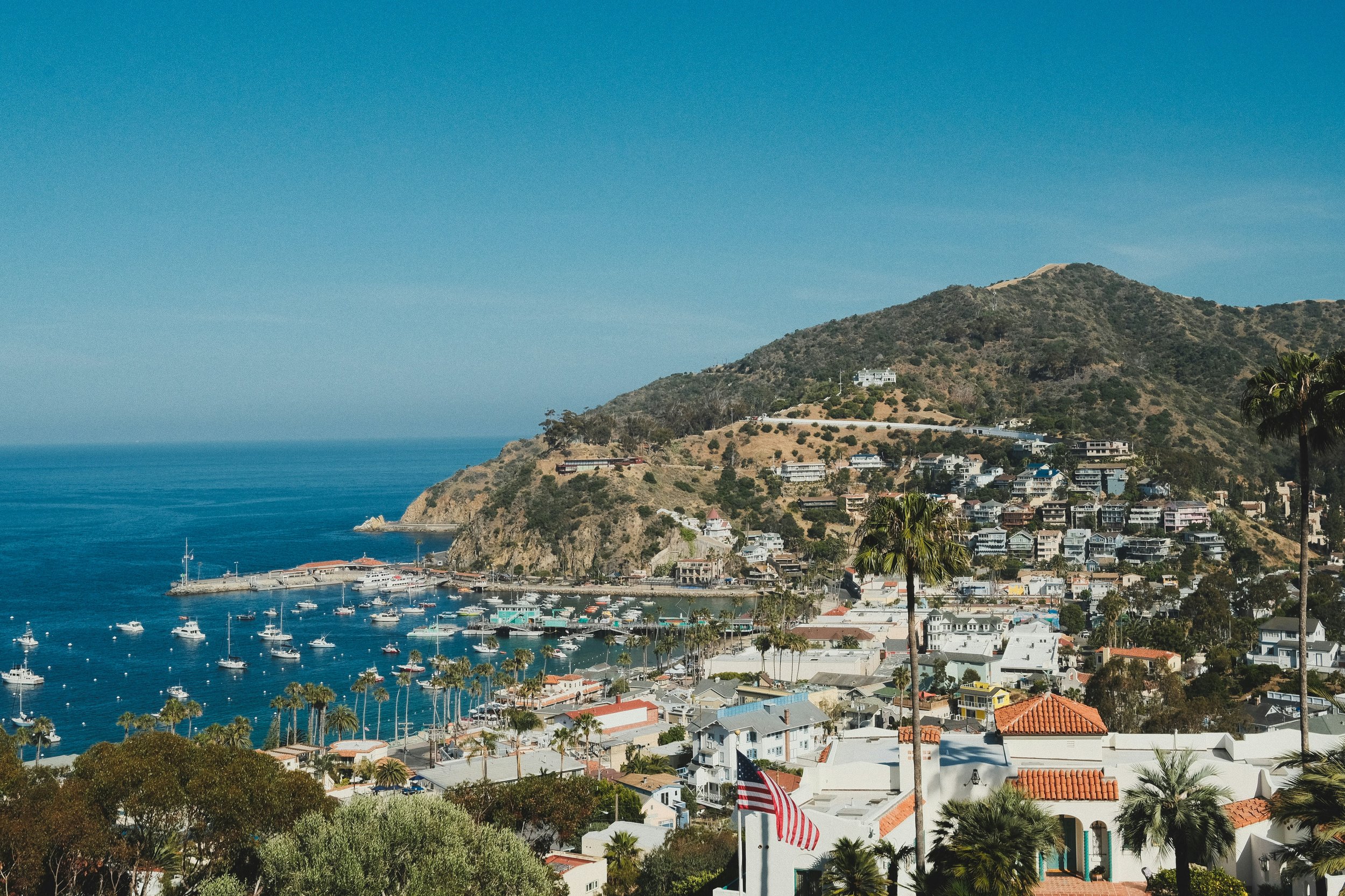 Mount Ada is perched in the hills above the city of Avalon on Catalina Island. The harbor is full of boats and the sky is almost the same colour as the water