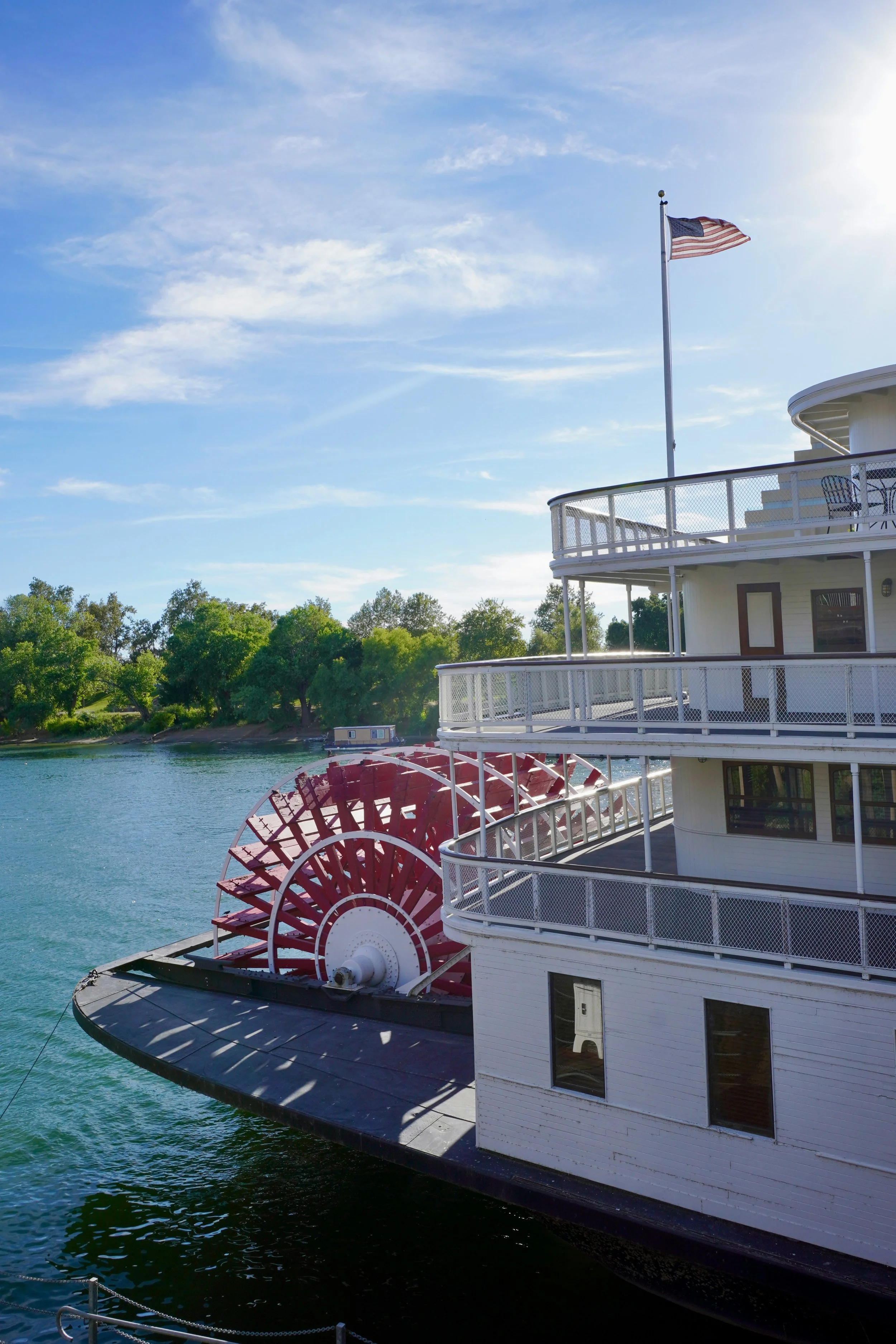 An American flag flies over the stern of the Delta King steamboat in Old Sacramento. Its paddles are a bright red