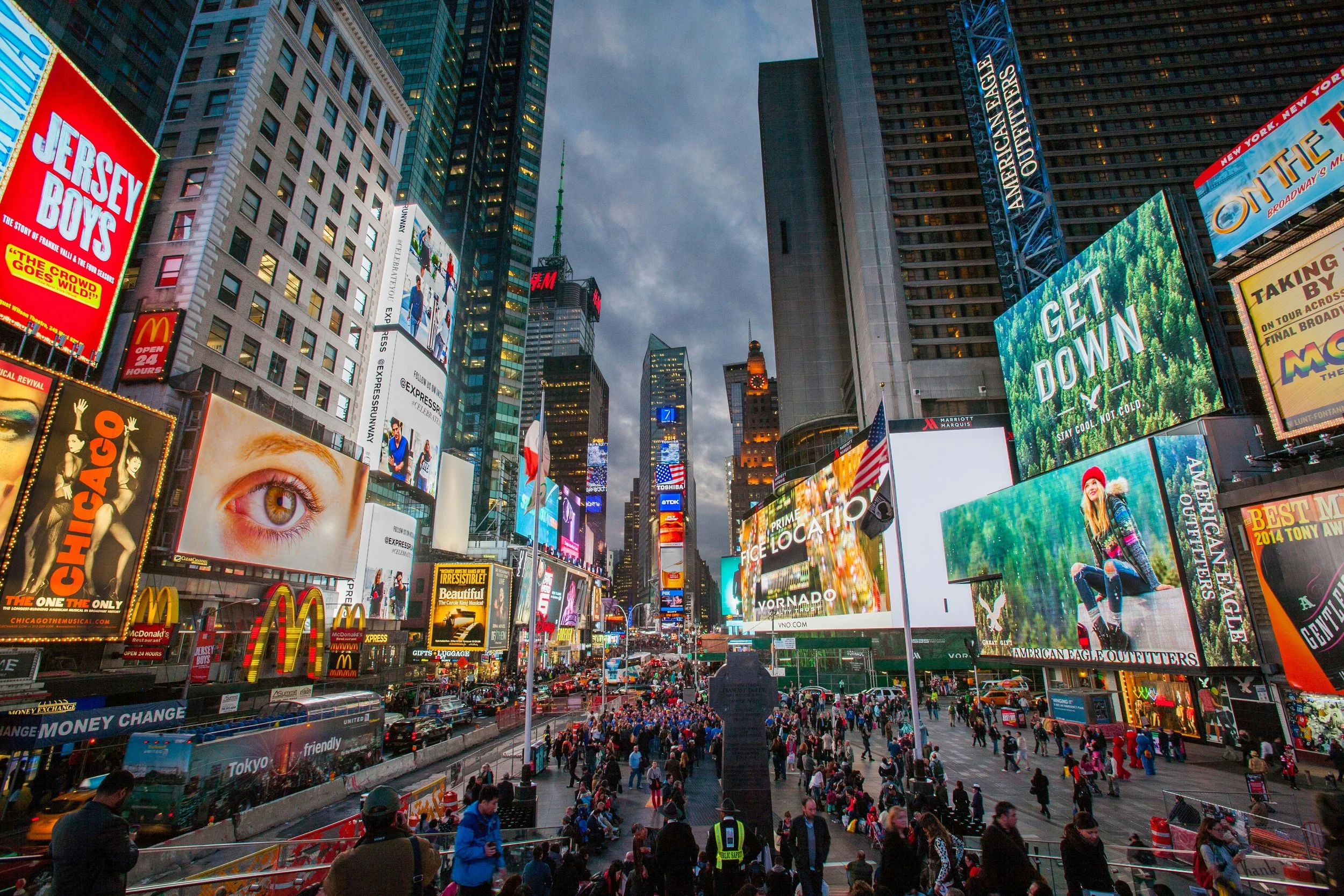 People fill Times Square, New York, surrounded by billboards for Broadway shows, restaurants and skyscrapers.