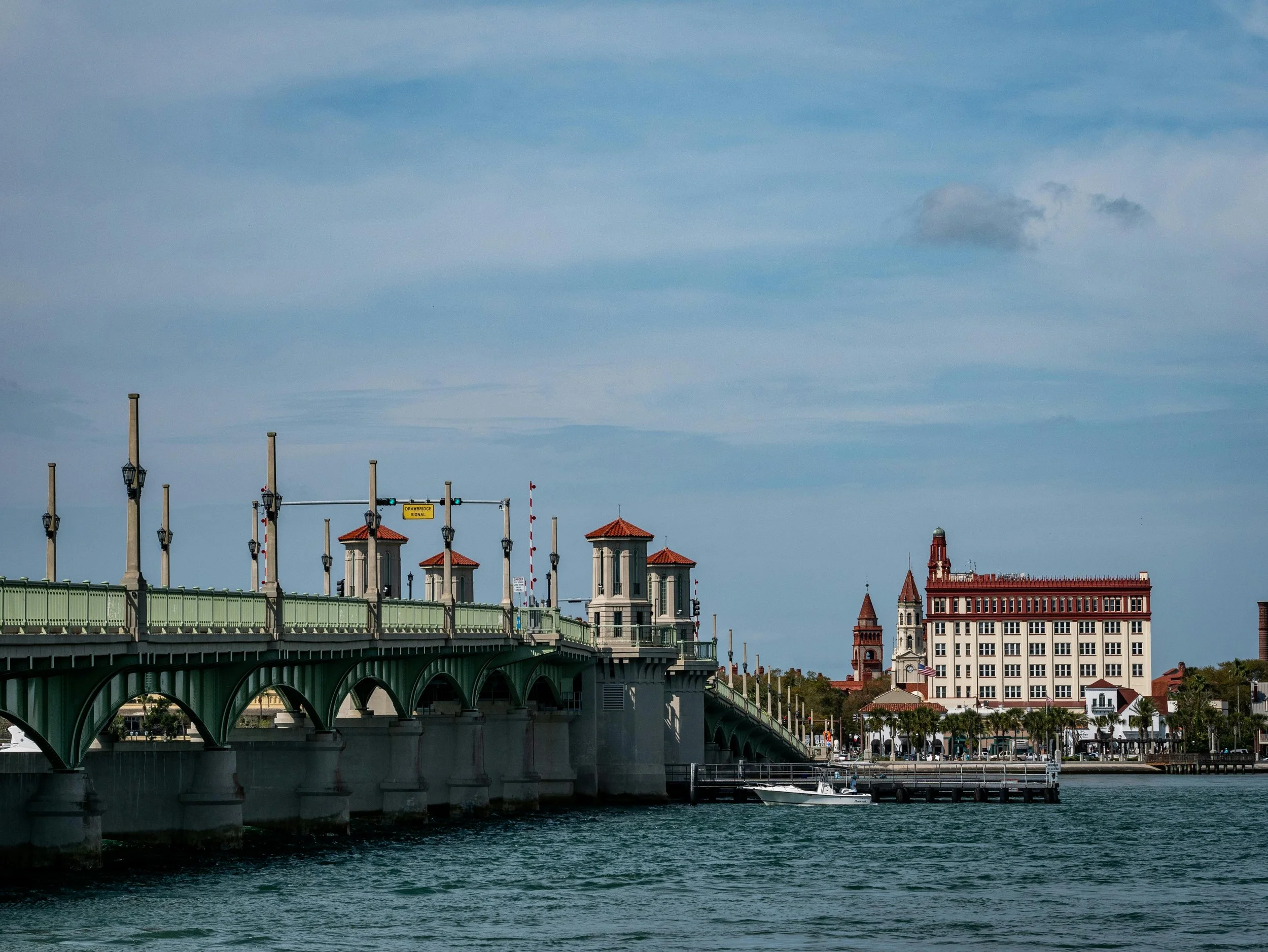 The Bridge of Lions croses the Matanzas River, with a large colonial-style building and the Cathedral Basilica of St. Agustine at its end