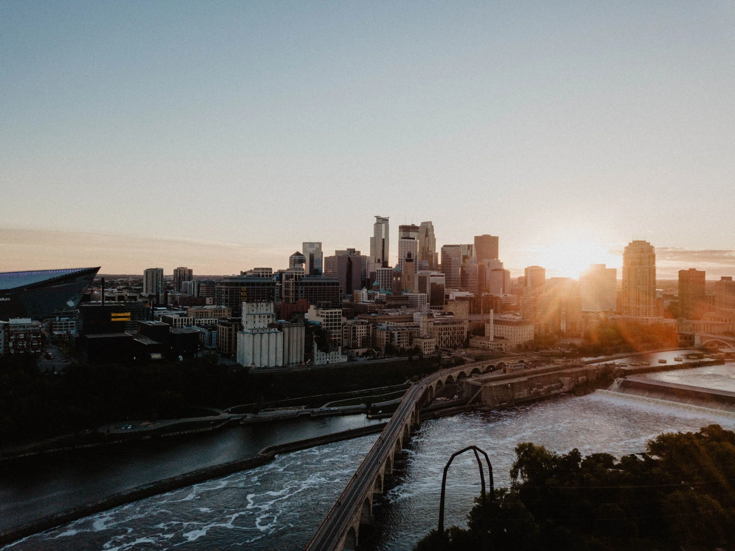 The sun sets over the Stone Arch Bridge, Mississippi River and Mill City, Minneapolis