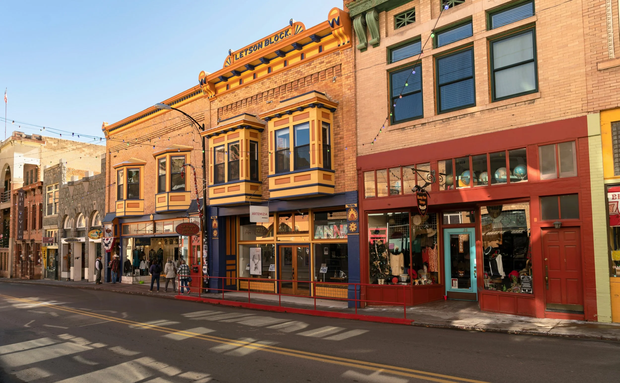 Old Wild West style buildings line a street in a town in Arizona. Drives & Detours Bisbee Tour