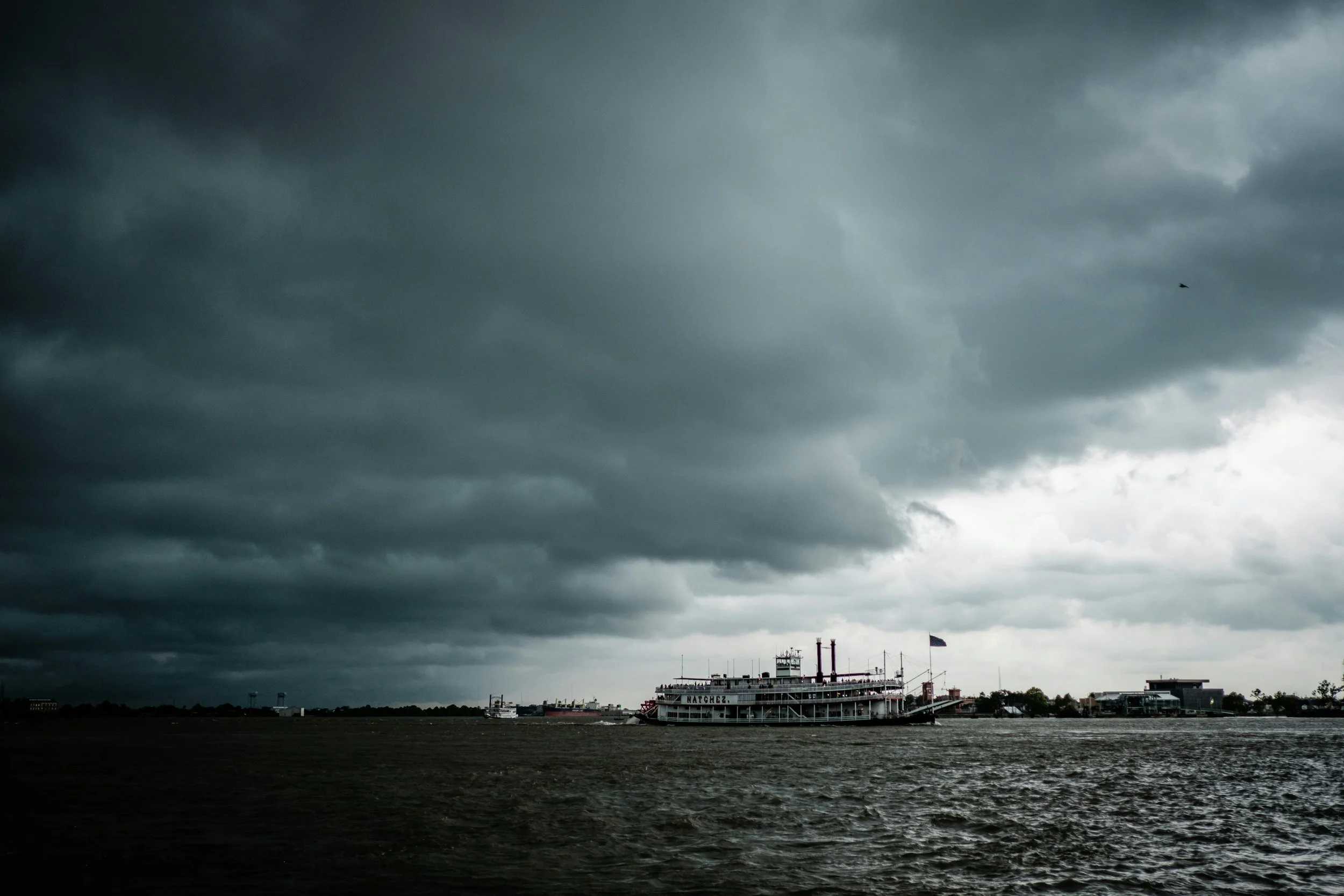 Steamboat Natchez sails into port, chased by dark storm clouds. Drives & Detours French Quarter walking tour