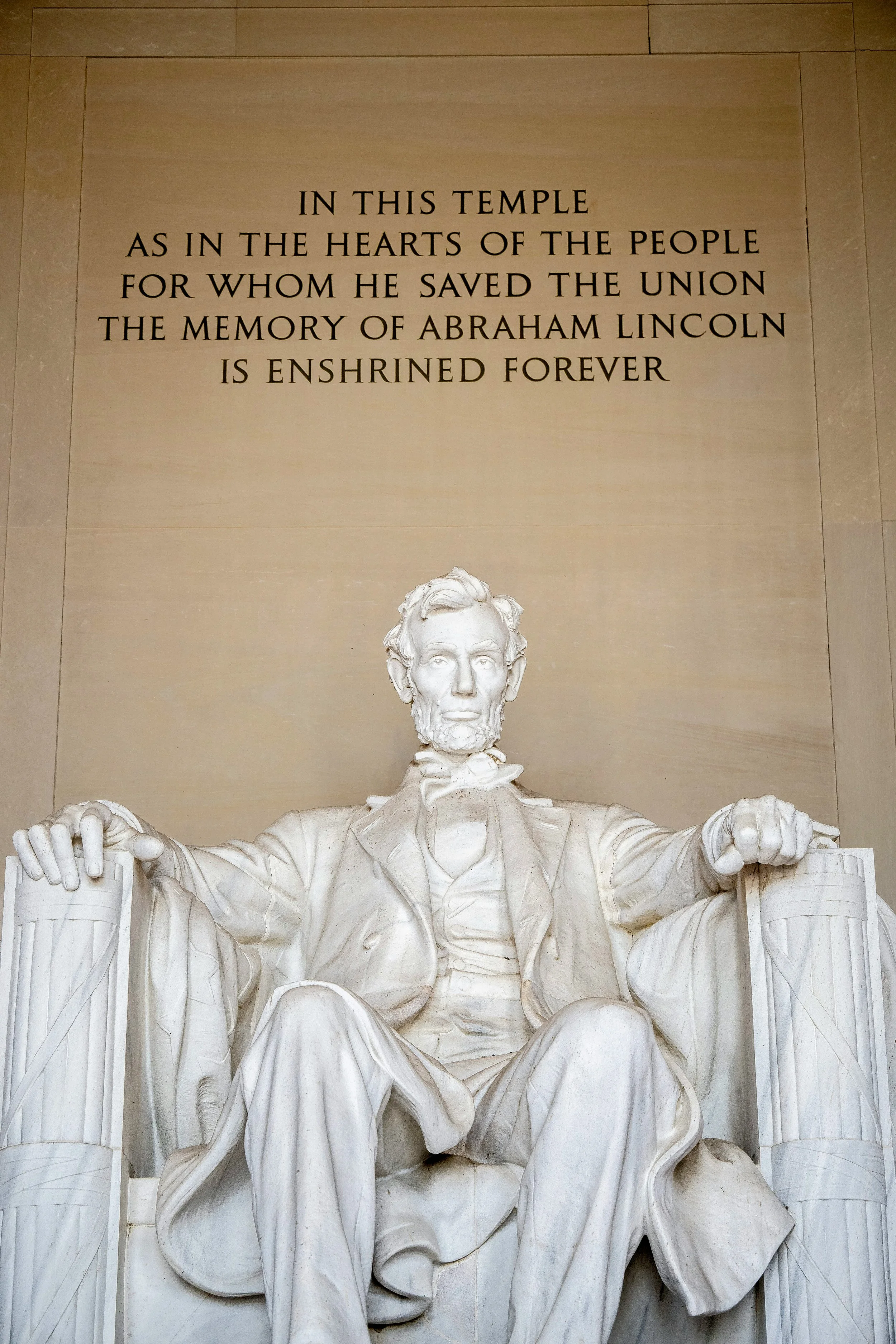 The staue of Abraham Lincoln on the National Mall in Washington DC, is white marble and huge.