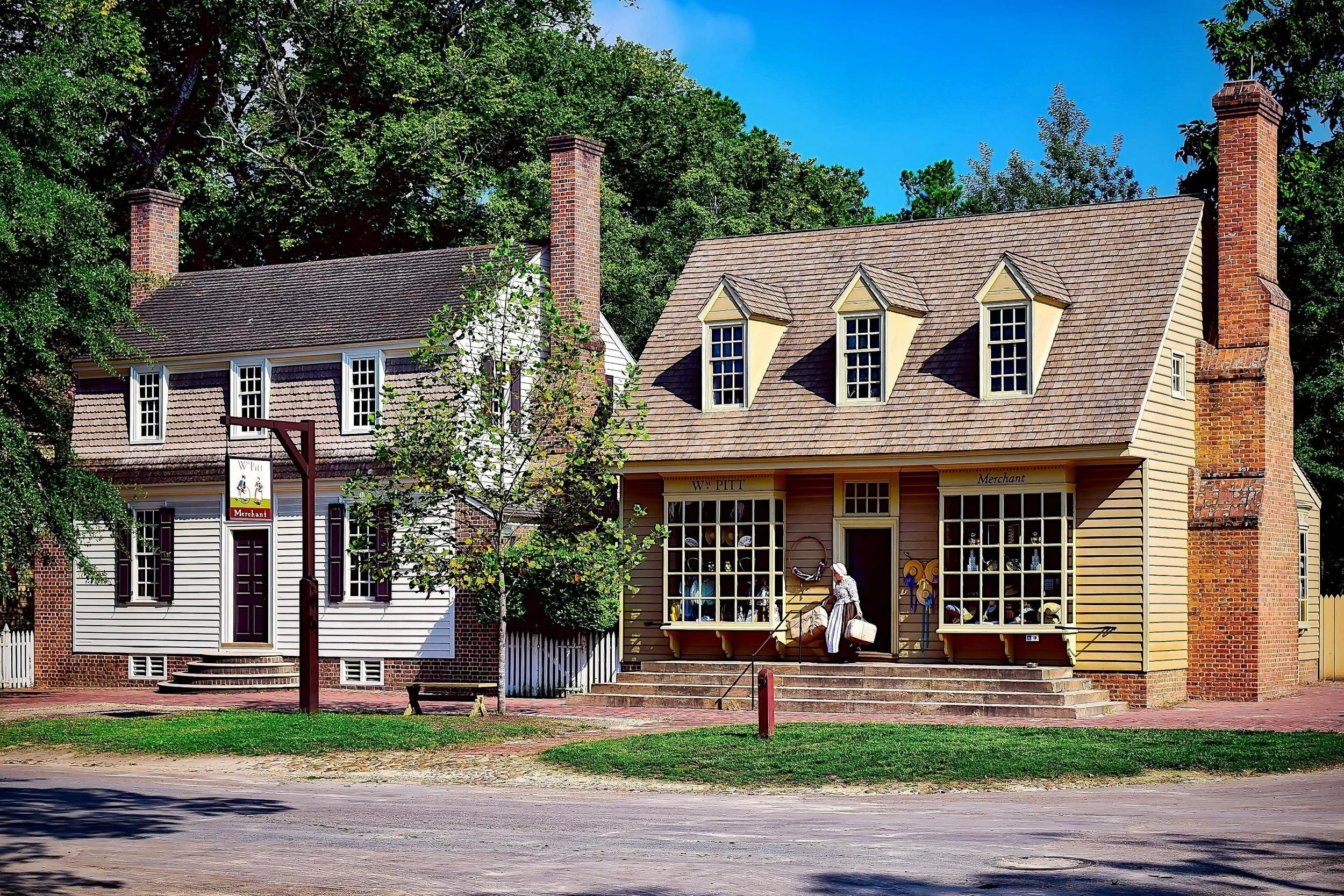 Two wooden buildings in Williamsburg. One is William Pitt, The Merchant, and the other looks like a house
