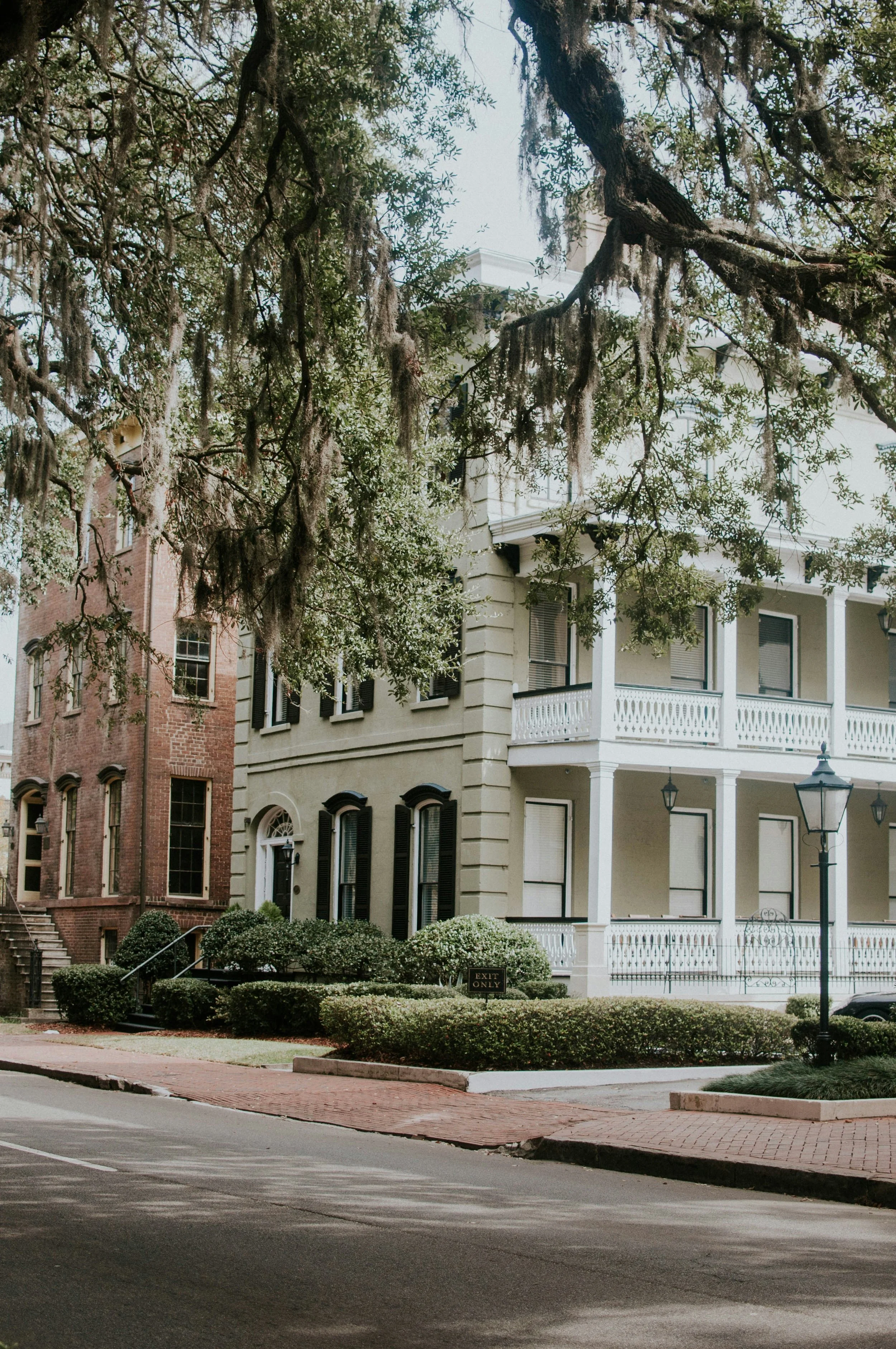 An old white house in Savannah, Georgia, surrounded by the famous live oak trees. Drives & Detours Savannah self-guided tour