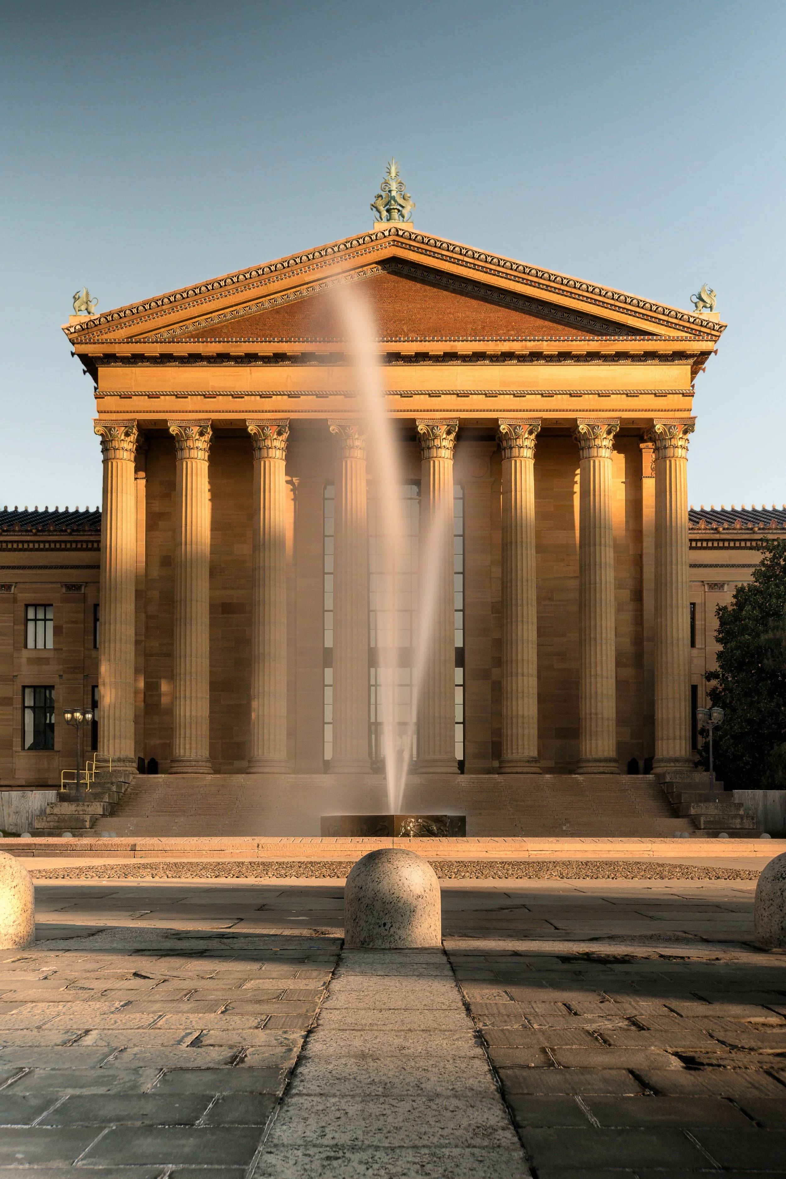 A fountain sprays water into the air in front of the Philadelphia Museum of Art