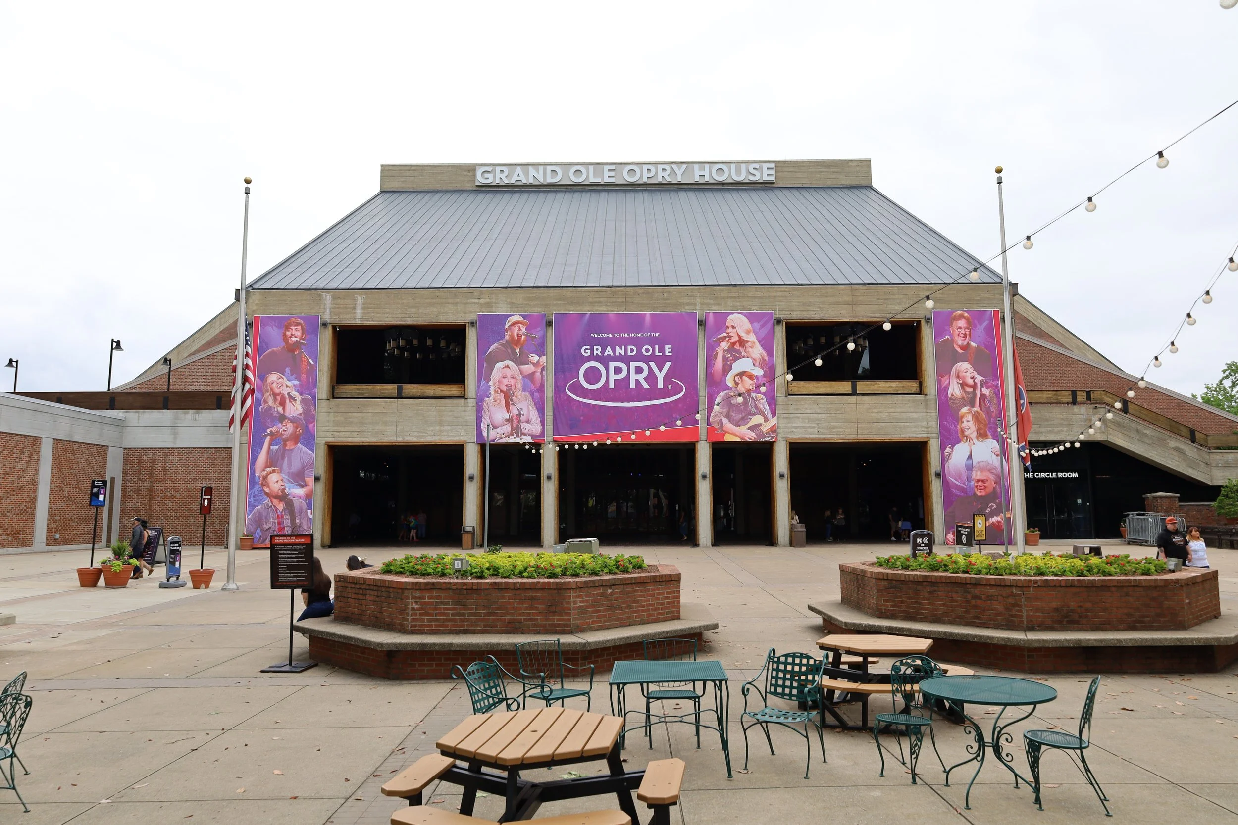 An exterior shot of the Grand Ole Opry, with banners showing different musicians. Drives & Detours Downtown Nashville walking tour