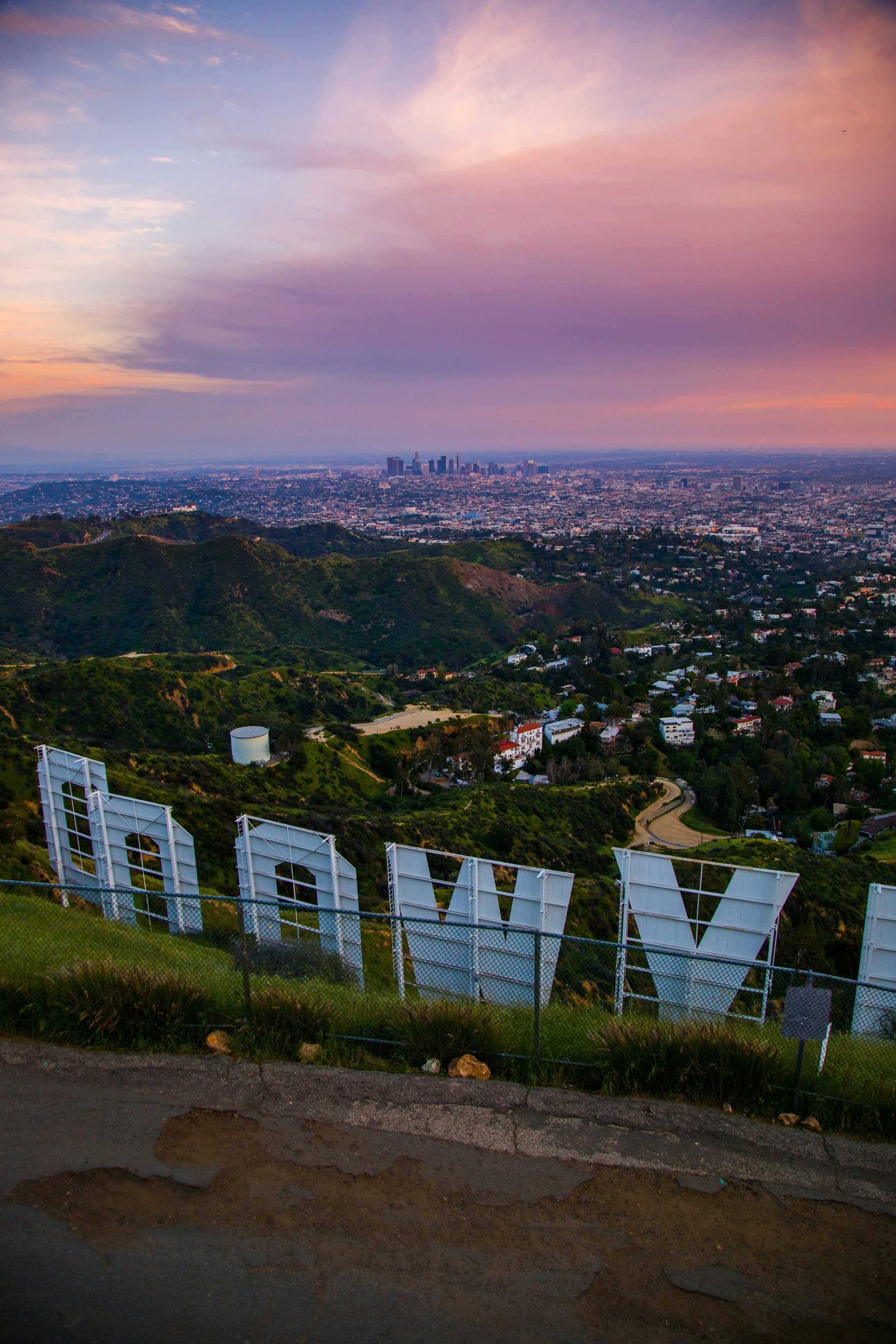 A shot of Downton Los Angeles from behind the Hollywood Sign at sunset, so everything is a bit pink.