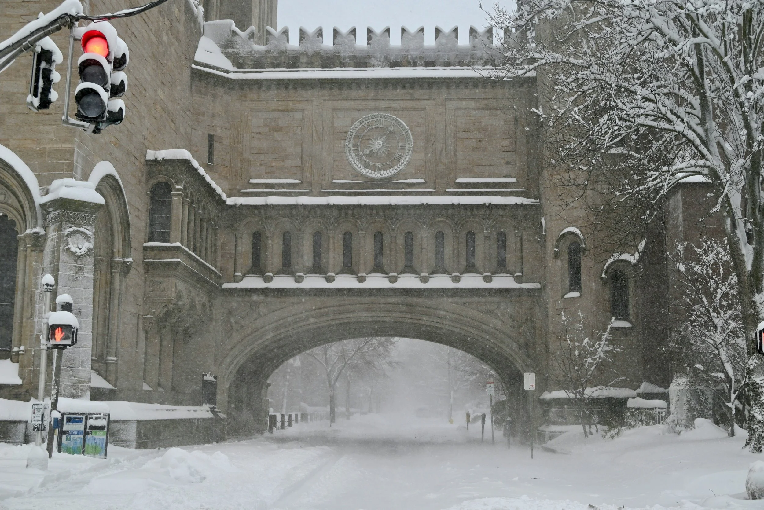 A snow-covered road goes under a large archway with a clock during a blizzard at Yale University. Drives & Detours New Haven travel tips