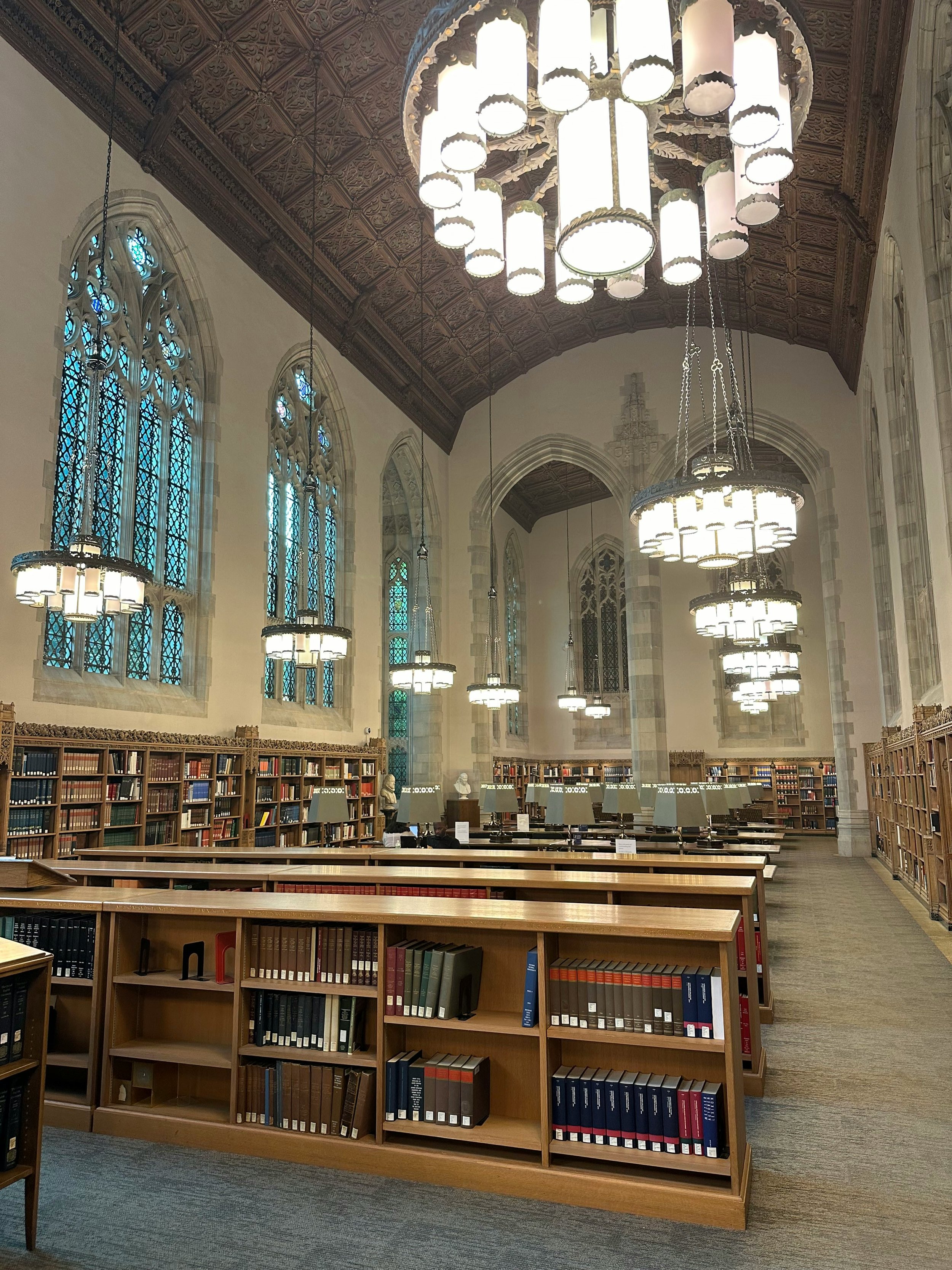 A library inside a building that could be a church. Chandeliers hang from the roof. Drives & Detours Yale Campus Tour