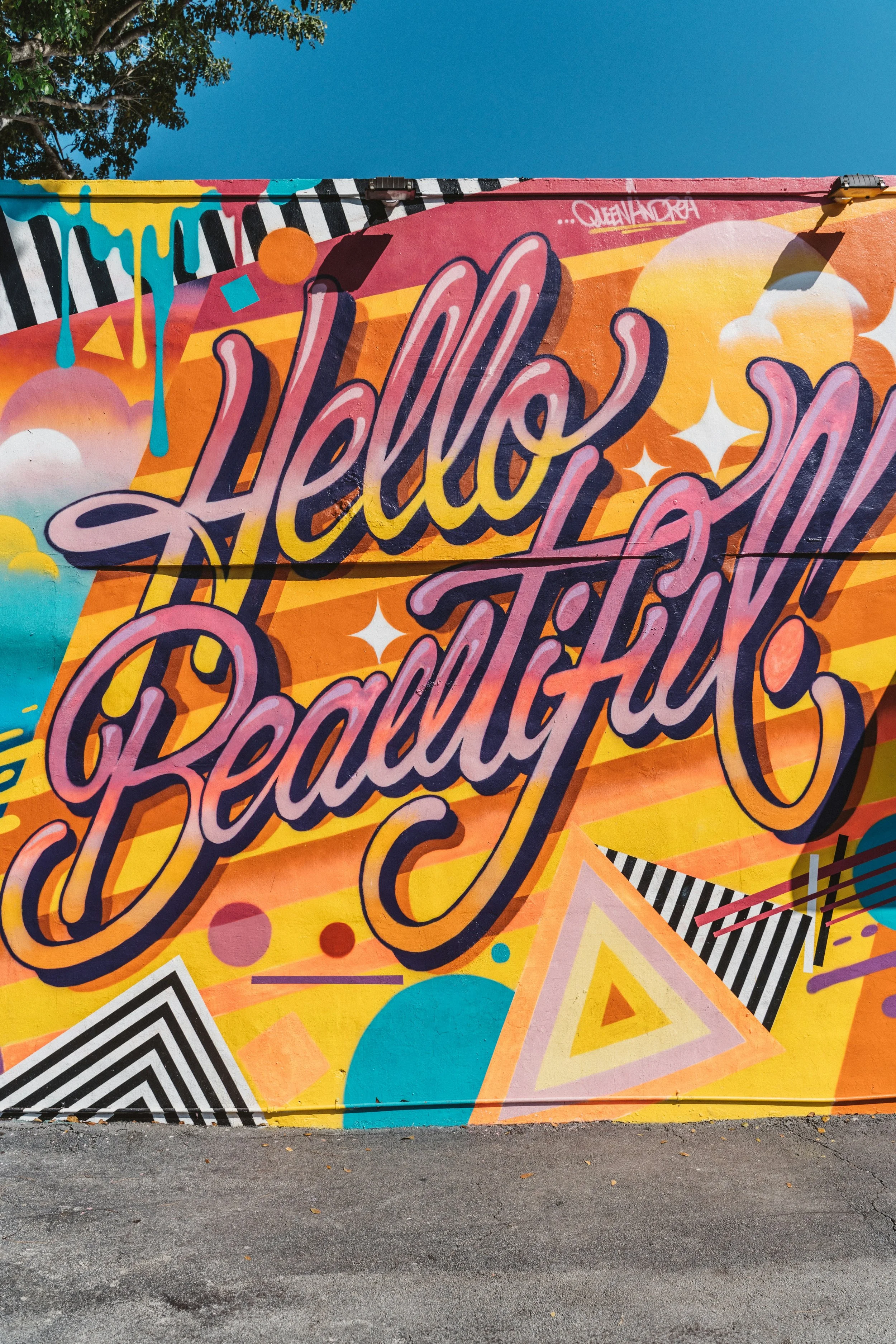 Bright orange and pink street art reads: "Hello Beautiful" in Wynwood, Miami