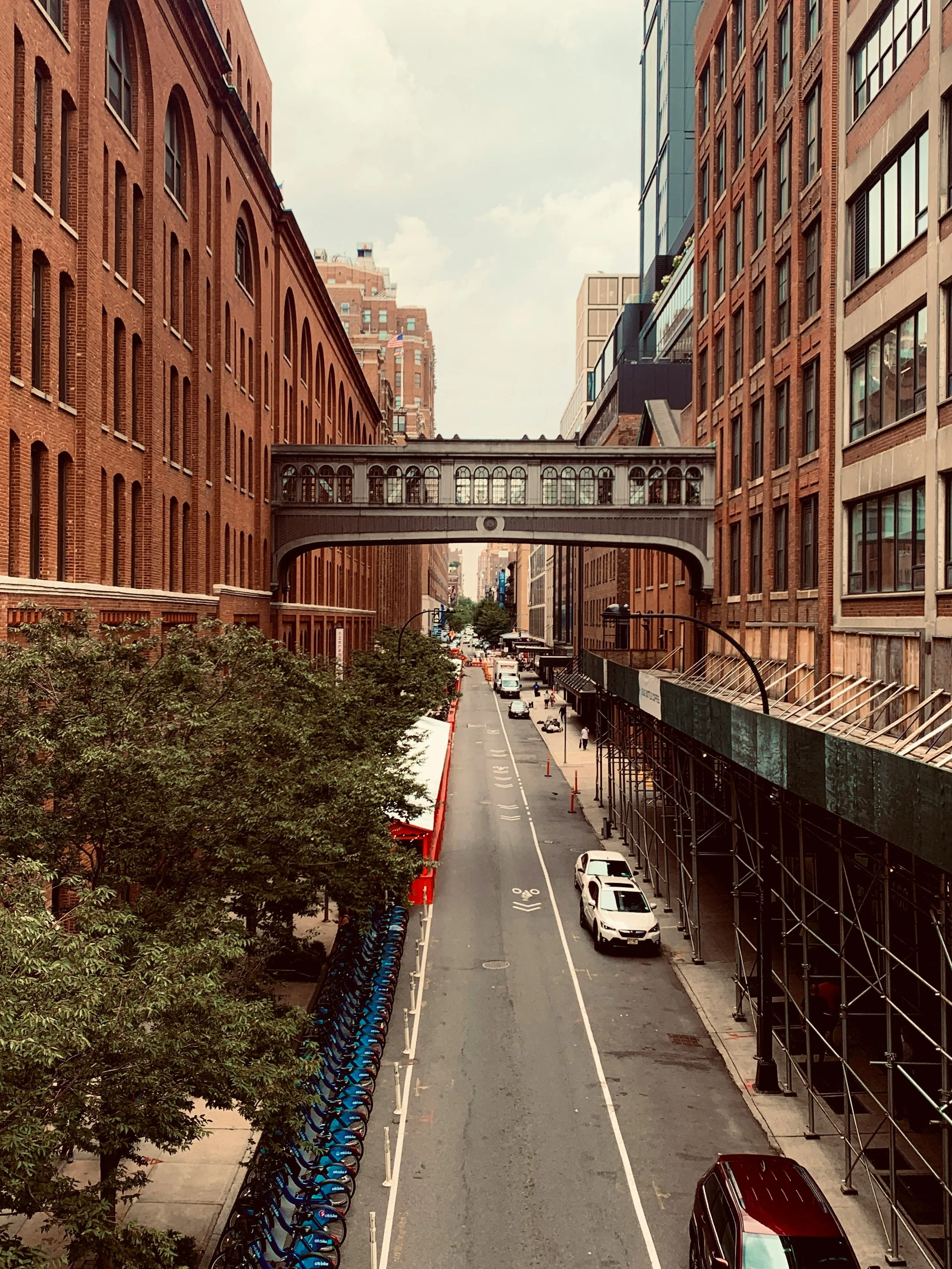 An iron bridge connects two buildings over a road in Chelsea Market, New York. Drives & Detours New York High Line walking tour