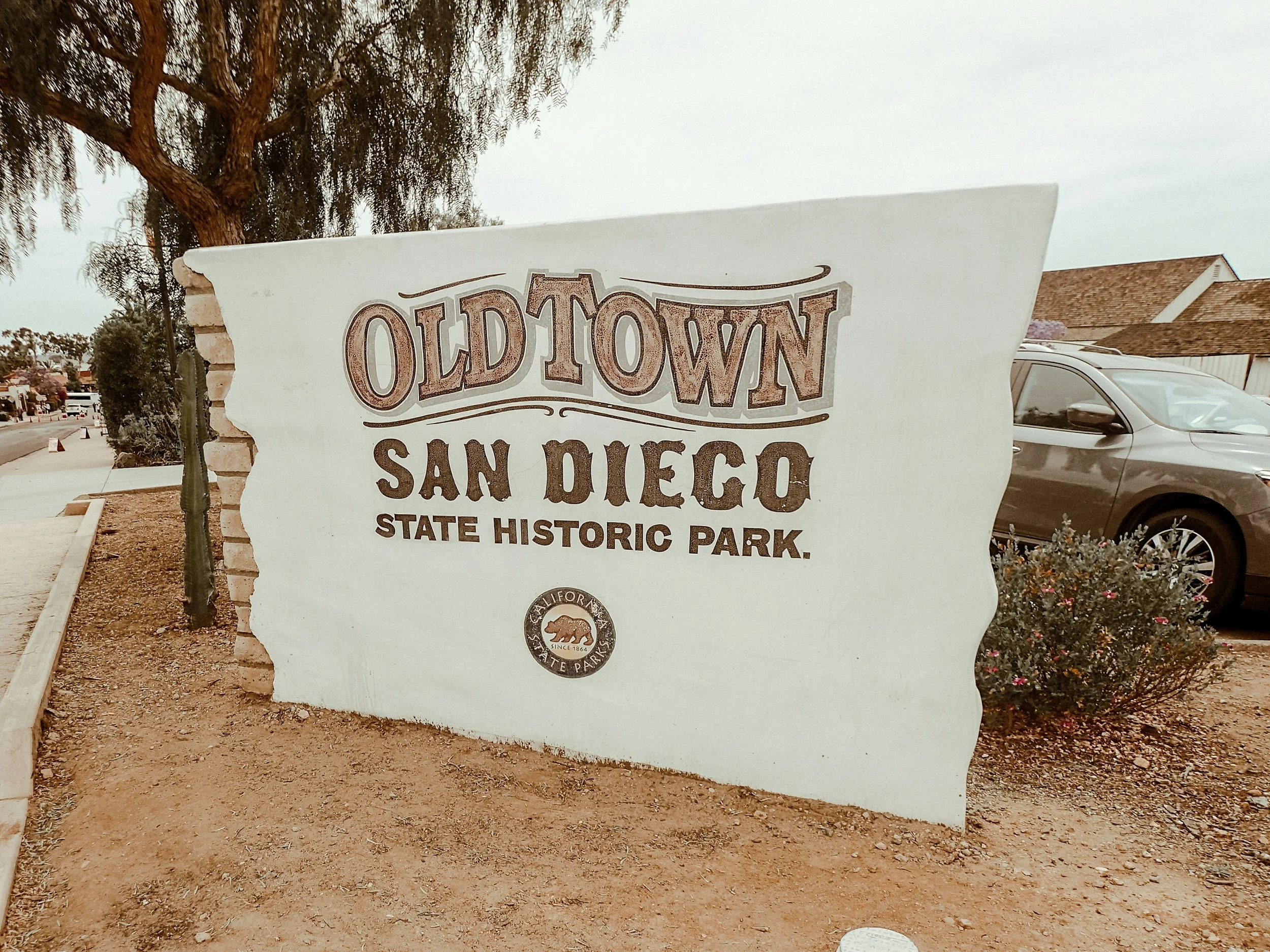 A sign displaying the park name at the entrance to Old Town San Diego State Historic Park. It is written in Wild West lettering