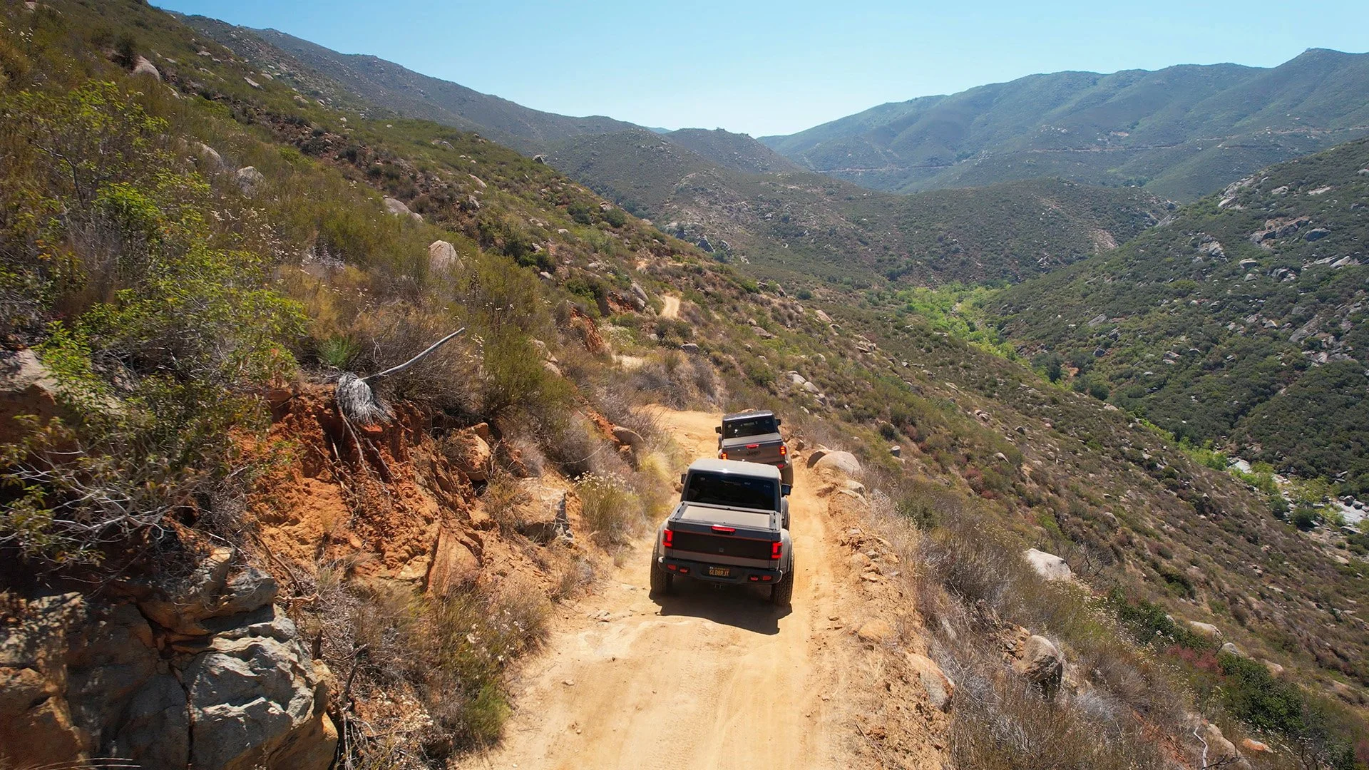 Two pick-up trucks drives along a trail through a valley in the Anza-Borrego Desert. Drives & Detours and San Diego Off-Road Adventures