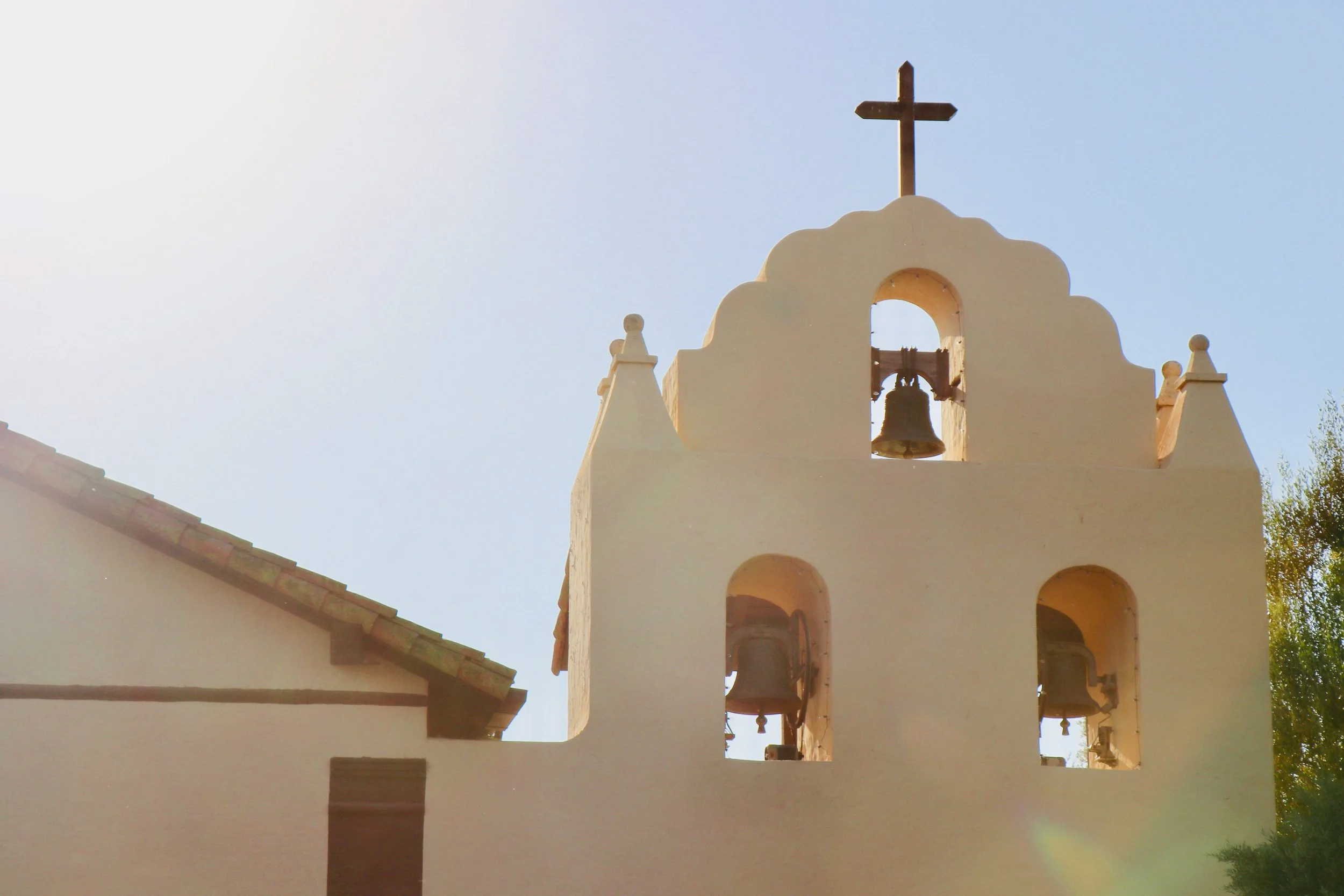 Church bells are built into a white wall with a cross on top in a detail of Mission Santa Inés. Drives & Detours Top sights in Solvang California