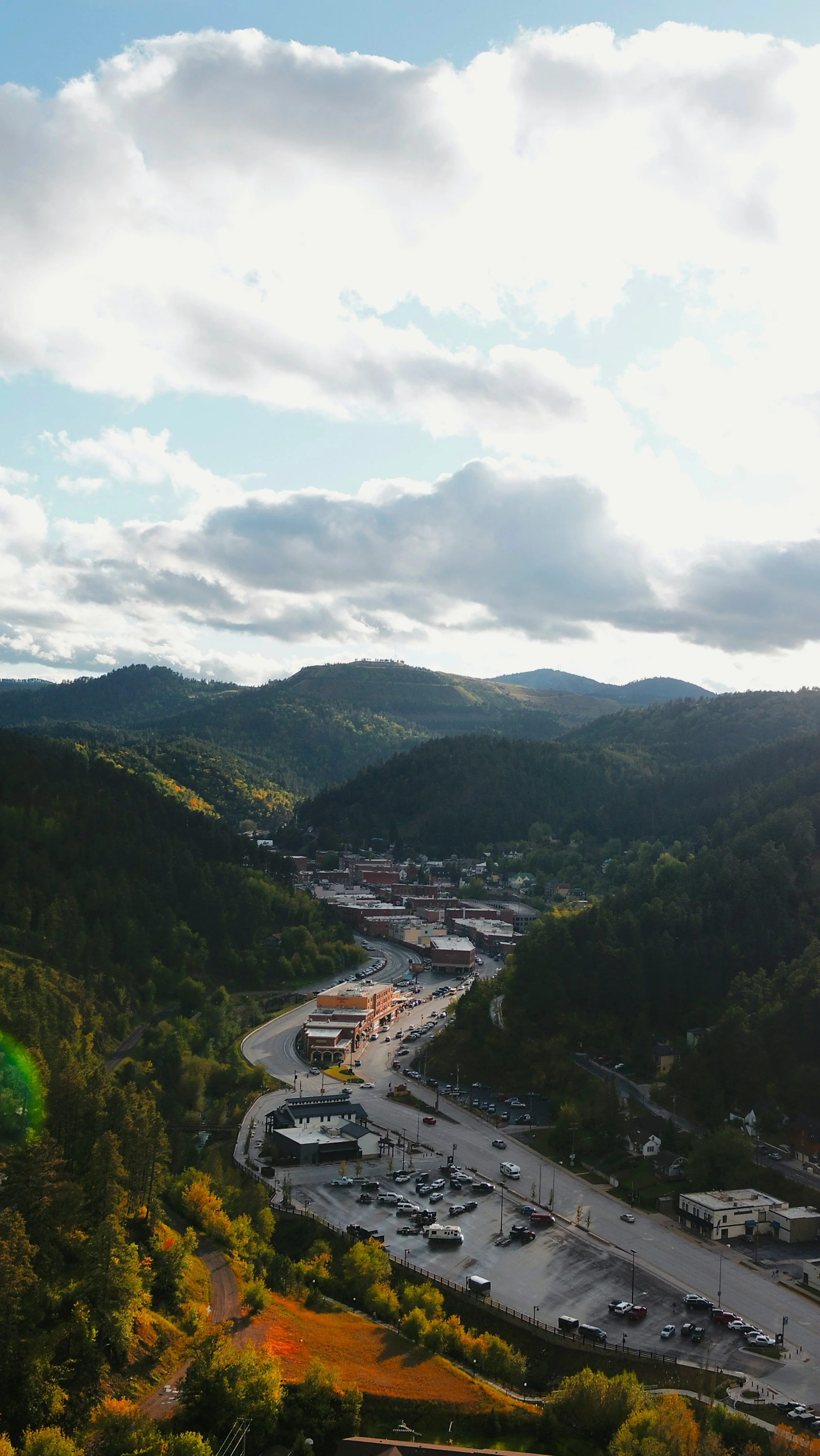 An aerial shot of a small South Dakota town in a large valley. Drives & Detours Deadwood tour