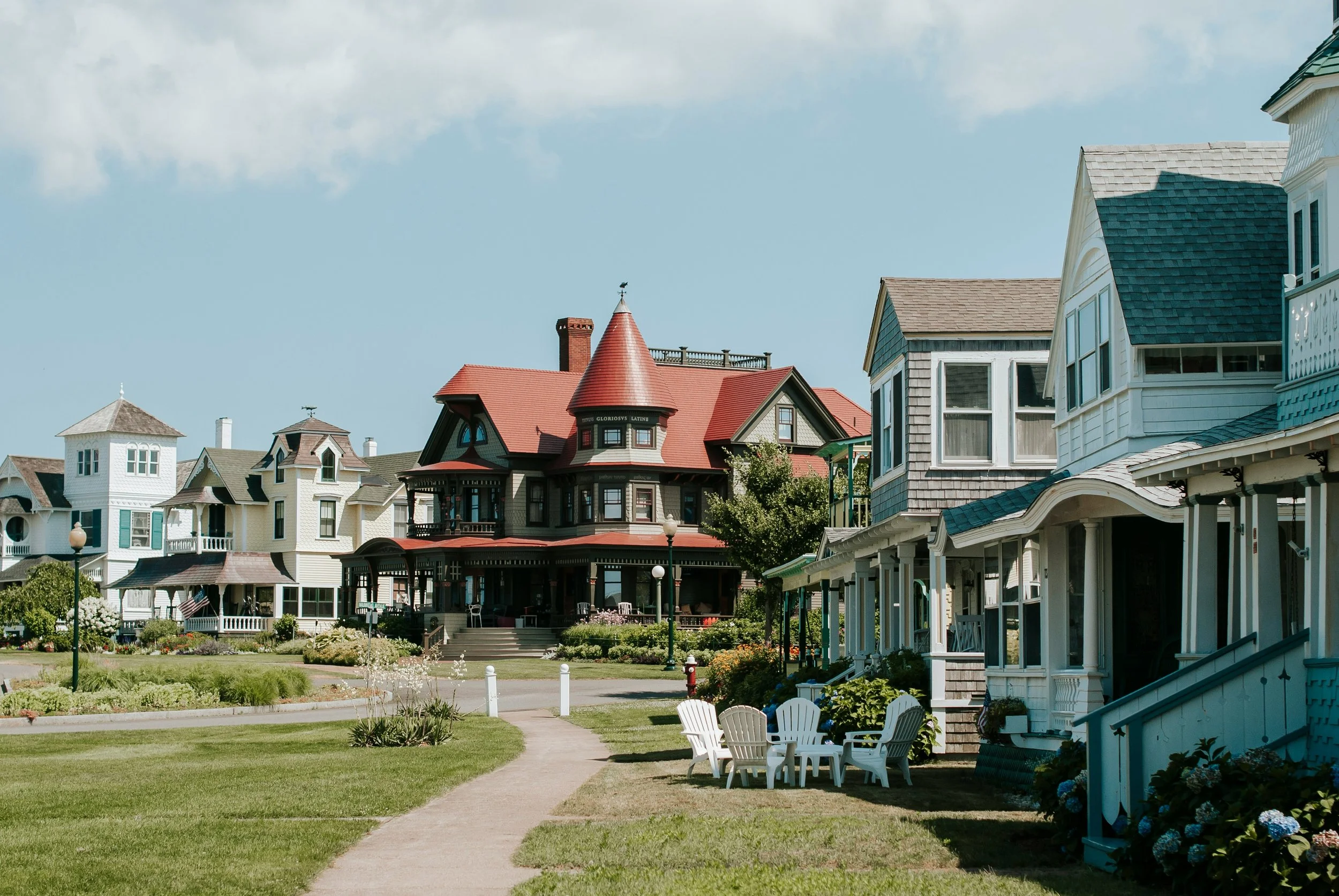 The old houses of Oak Bluffs, Martha's Vineyard. ONe has a red roof and is three storeys. It's the The Corbin Norton House