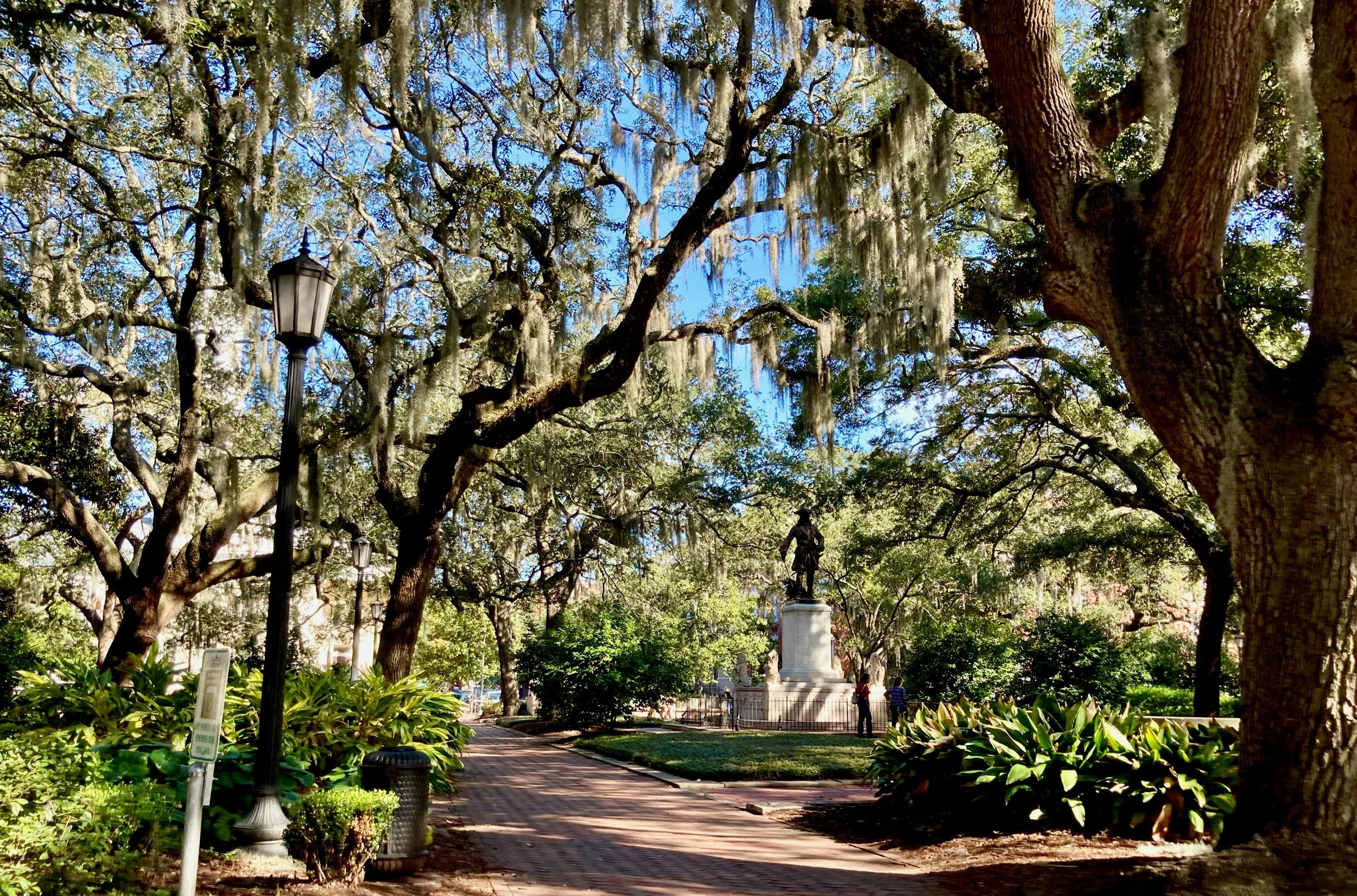 A statue is dwarfed by the live oaks of the sqaures in Georgia. Drives & detours Savannah local tips