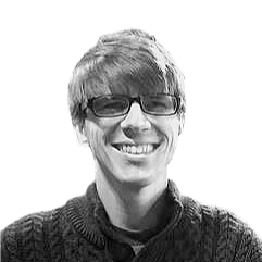 Patrick O'Brien, a person with short hair and glasses smiling, wearing a dark sweater.