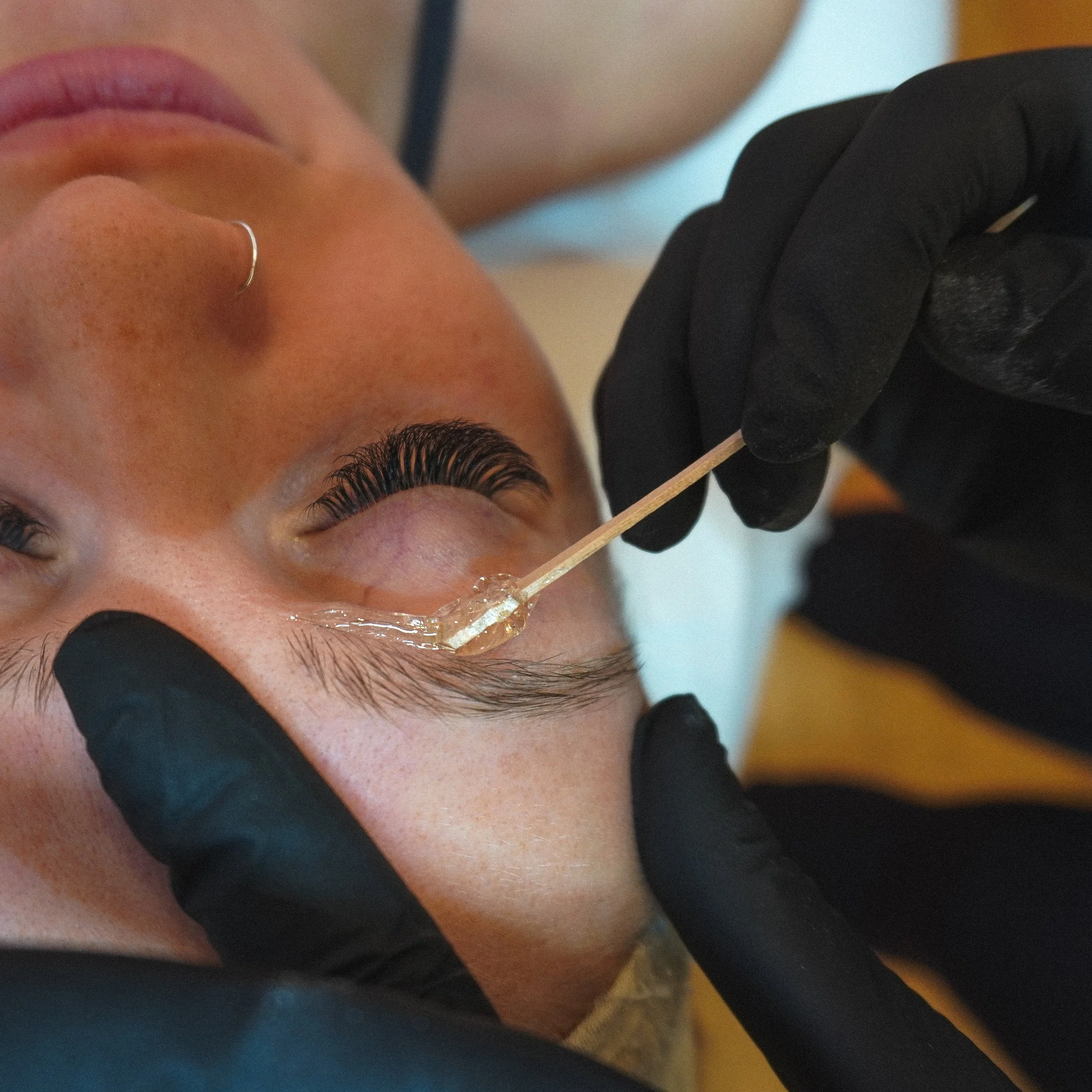 close-up of brow sugaring treatment on eyebrows