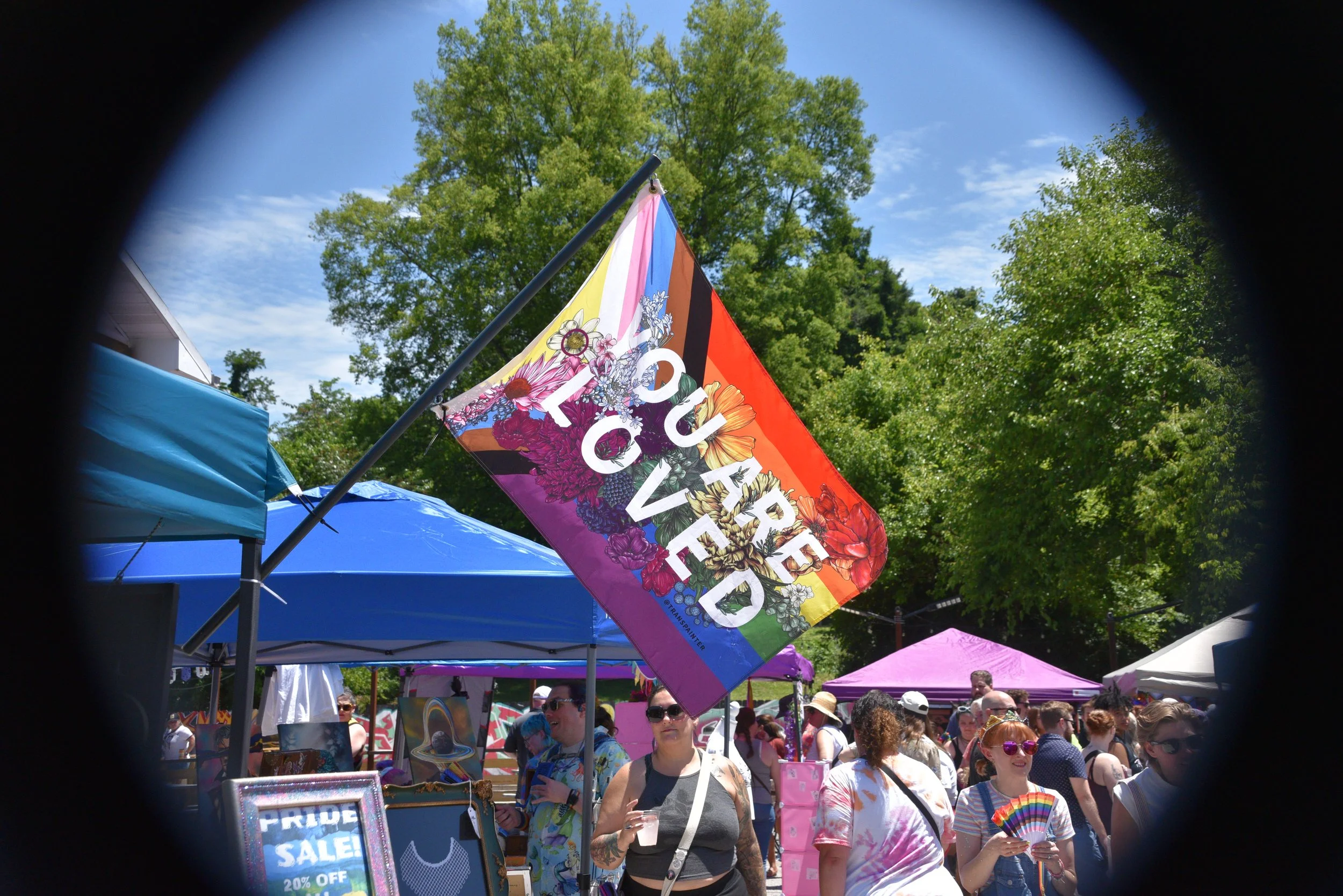 A colorful ‘You Are Loved’ Pride flag flies above the crowd at SoKno Pride.